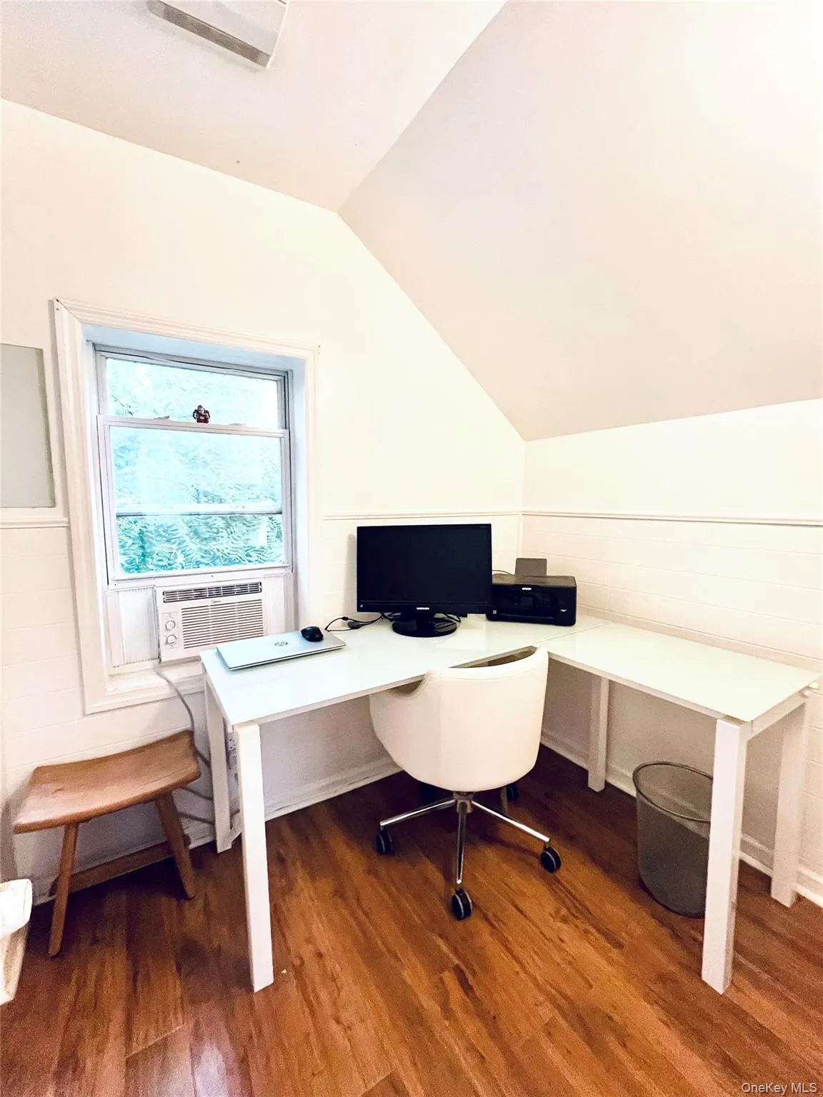 Wood-finish flooring, single window, sloped ceiling, and white wall finishes Wood-finish flooring, single window, sloped ceiling, and white wall finishes