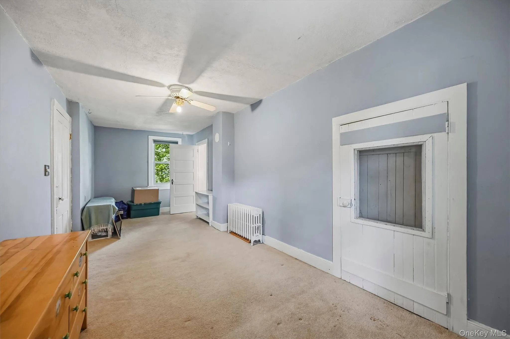 Ceiling fan light fixture, baseboard heating, window, white trim, and a built-in shelf Ceiling fan light fixture, baseboard heating, window, white trim, and a built-in shelf