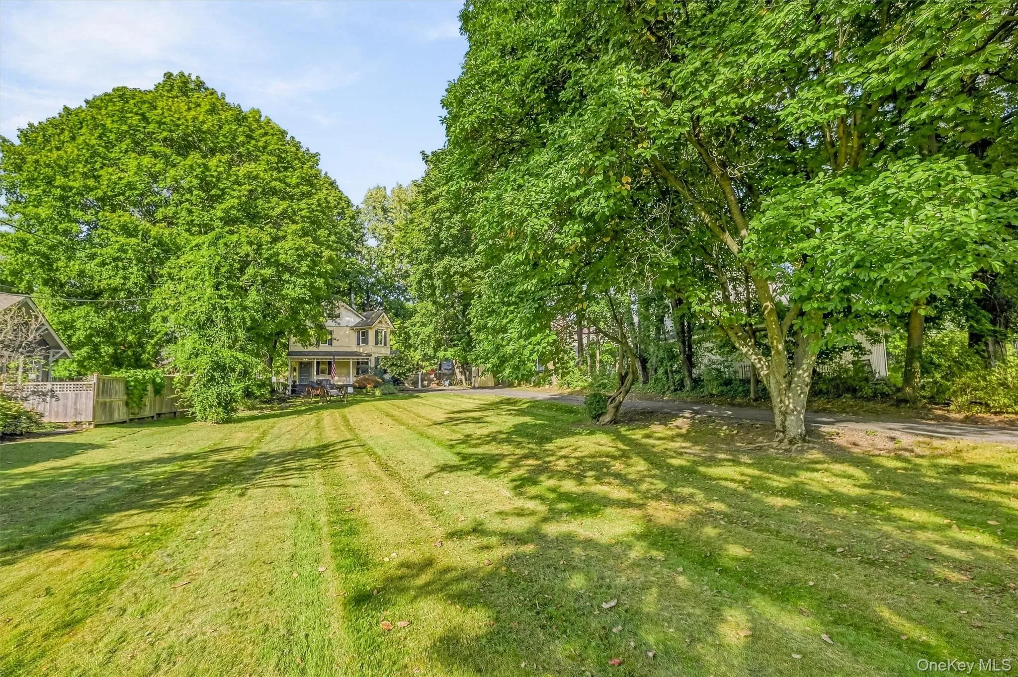 Expansive lawn surrounded by mature trees, providing a spacious outdoor setting Expansive lawn surrounded by mature trees, providing a spacious outdoor setting