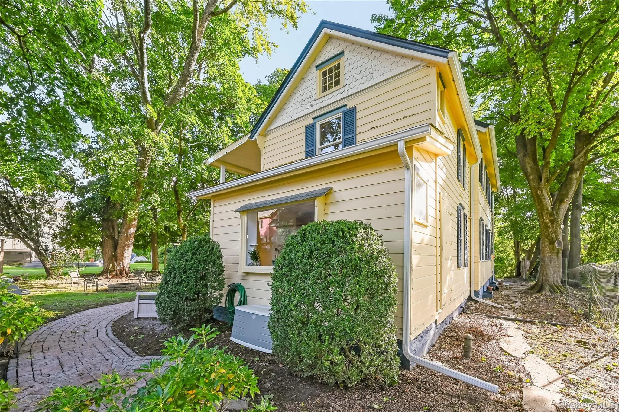 Rear view of the historic home surrounded by mature trees and established landscaping Rear view of the historic home surrounded by mature trees and established landscaping