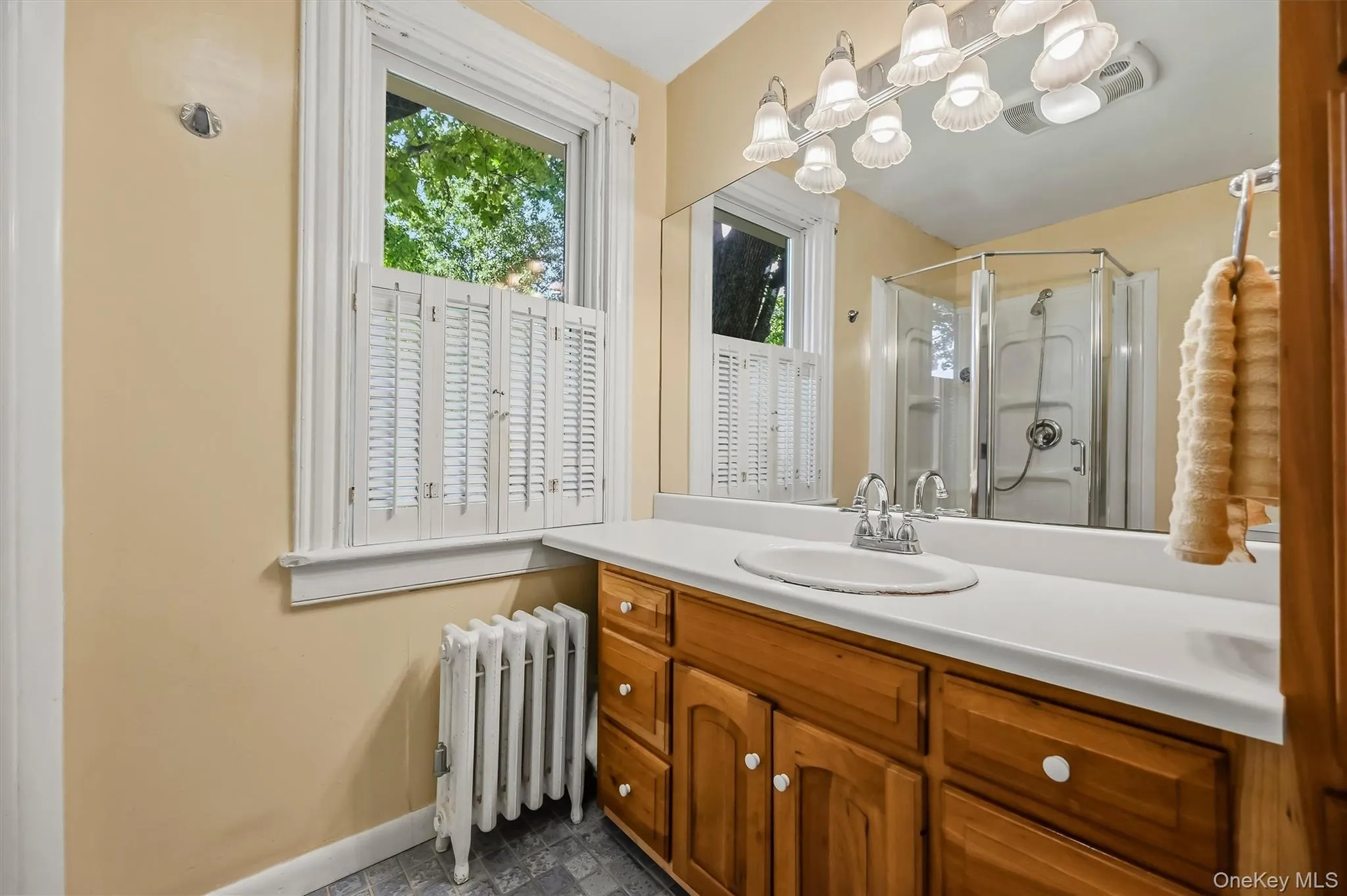 Full bath with wood vanity, large mirror, and walk-in shower Full bath with wood vanity, large mirror, and walk-in shower