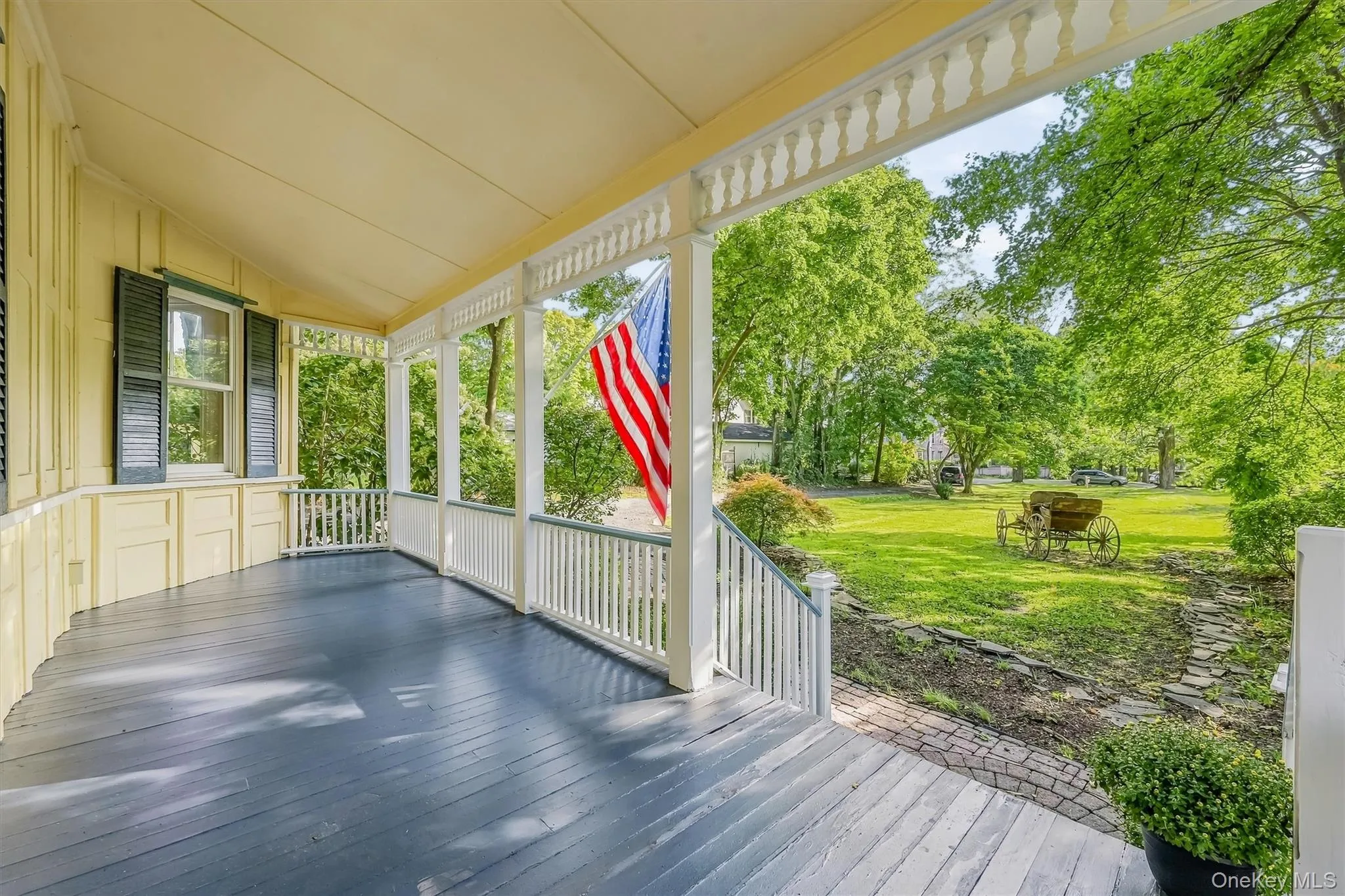 Covered porch with painted wood flooring and decorative balusters Covered porch with painted wood flooring and decorative balusters