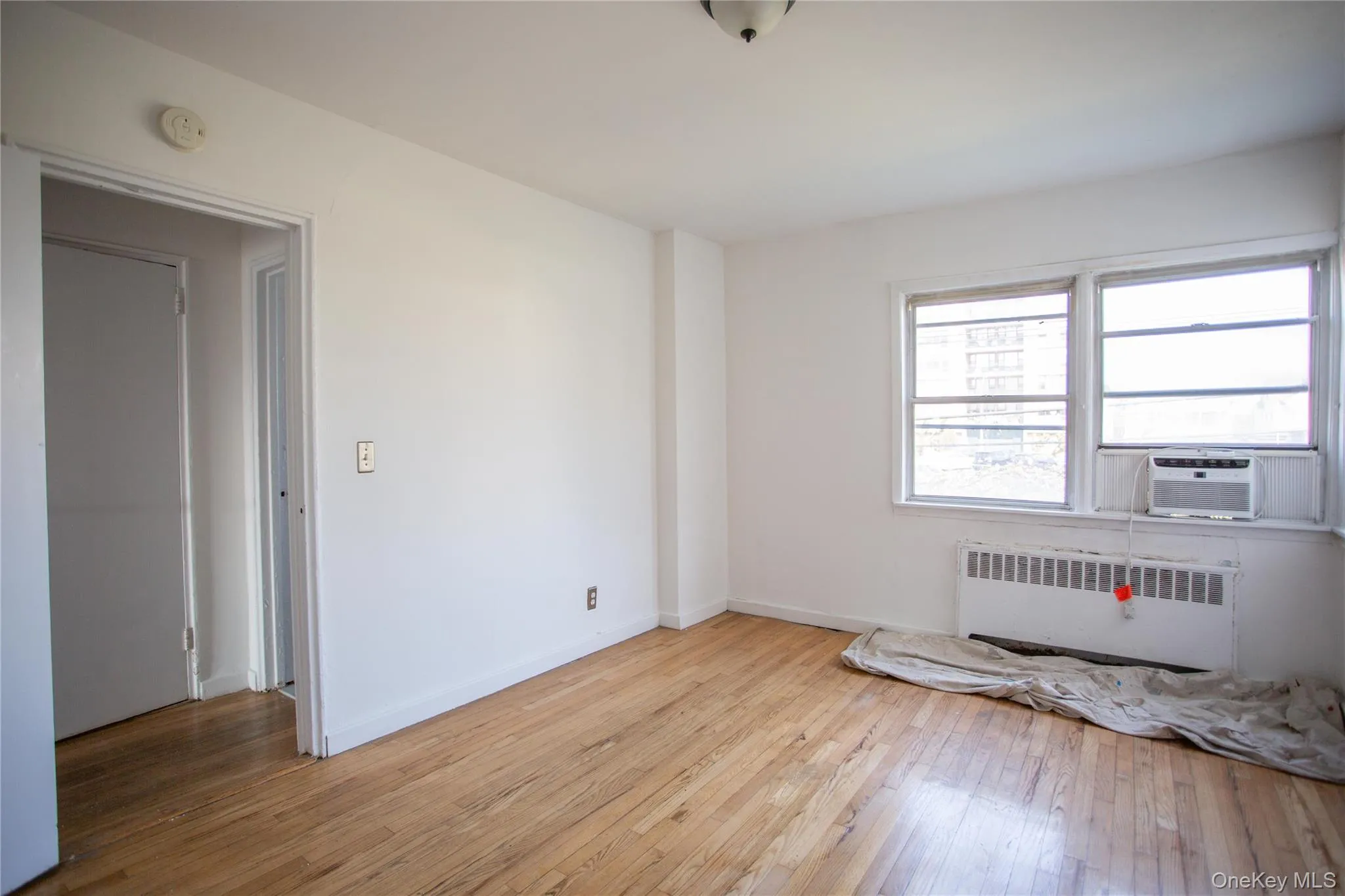 Spare room with radiator heating unit and light wood-style floors Spare room with radiator heating unit and light wood-style floors