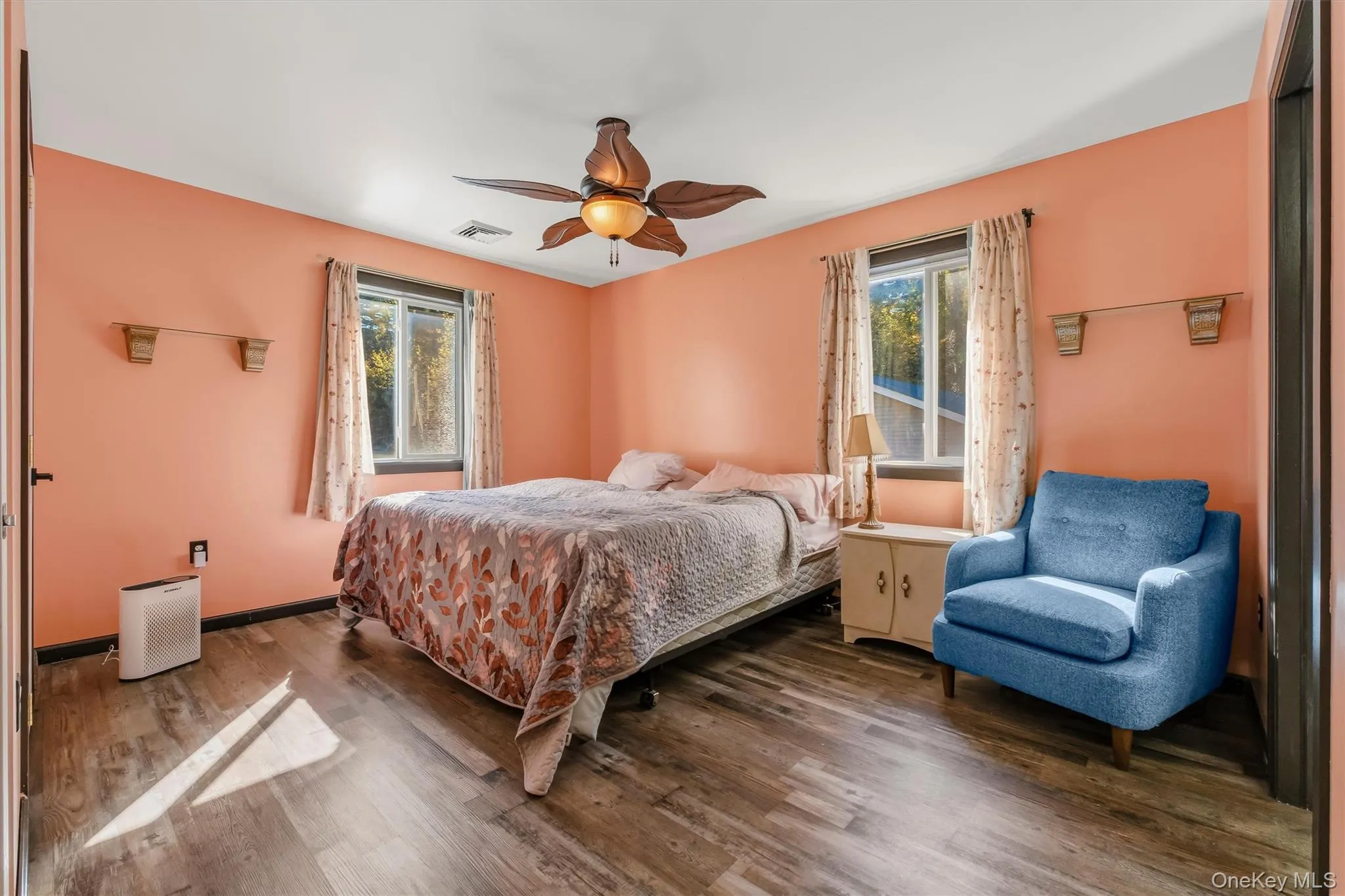 Primary bedroom with wood-finish flooring, and a ceiling fan with integrated lighting Primary bedroom with wood-finish flooring, and a ceiling fan with integrated lighting