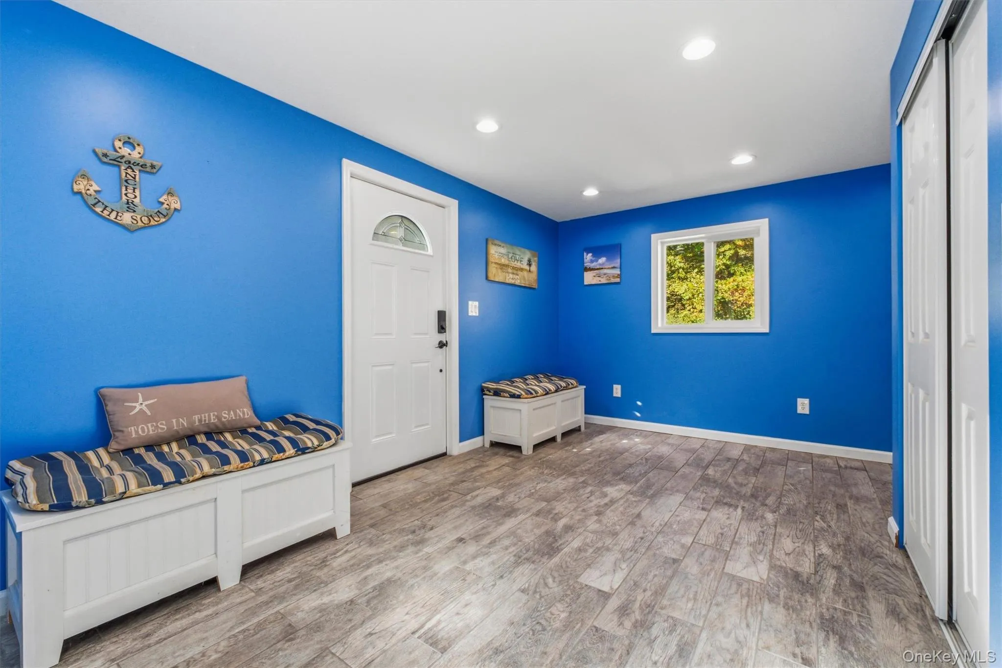 Entry foyer with Wood-finish flooring, recessed lighting, and a window with natural light Entry foyer with Wood-finish flooring, recessed lighting, and a window with natural light