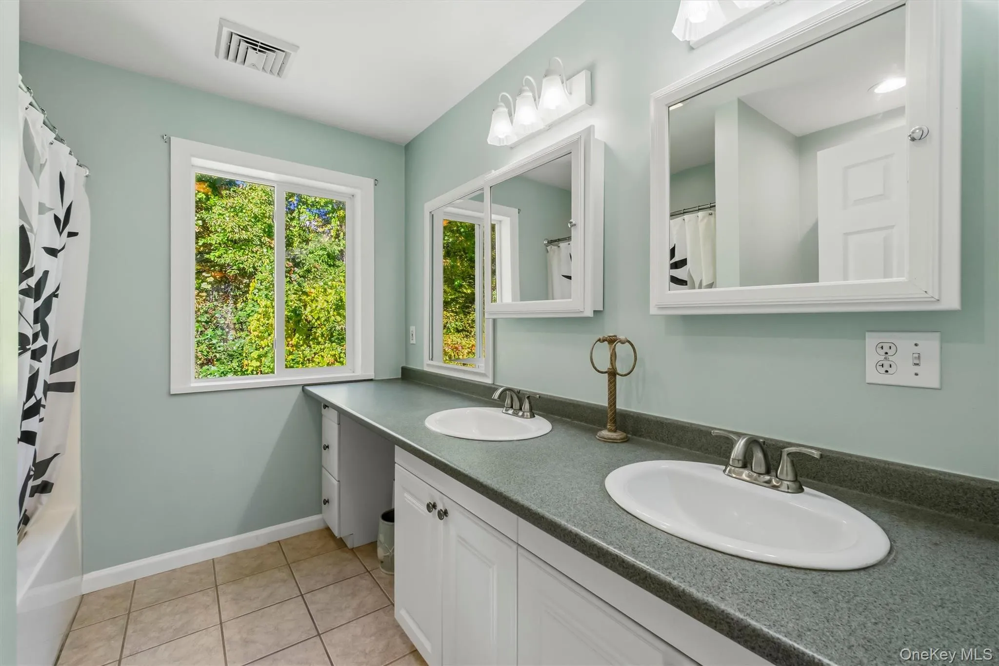 Dual vanity with undermount sinks, white cabinetry, and gray countertops Dual vanity with undermount sinks, white cabinetry, and gray countertops