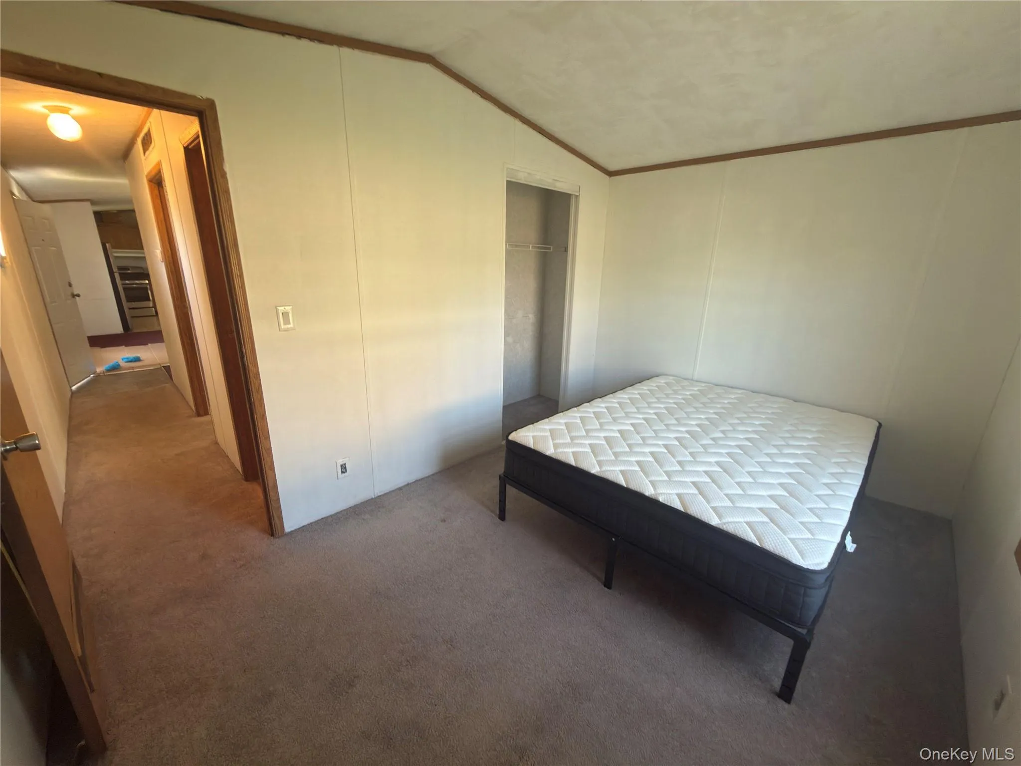 Carpeted flooring throughout, light-toned wall panels, and exposed wood trim Carpeted flooring throughout, light-toned wall panels, and exposed wood trim