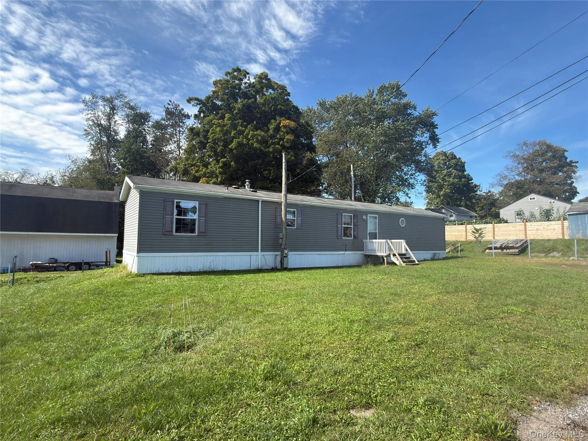 Single-story residence featuring gray siding and white trim Single-story residence featuring gray siding and white trim