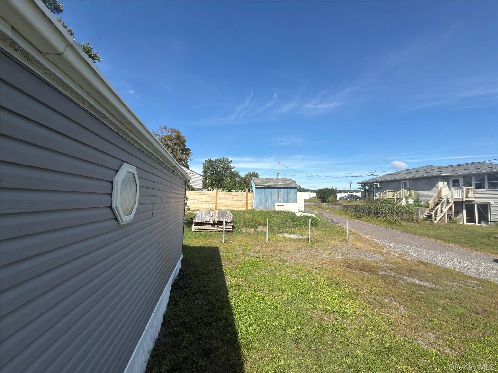 Gray siding exterior with white trim and an octagonal window Gray siding exterior with white trim and an octagonal window