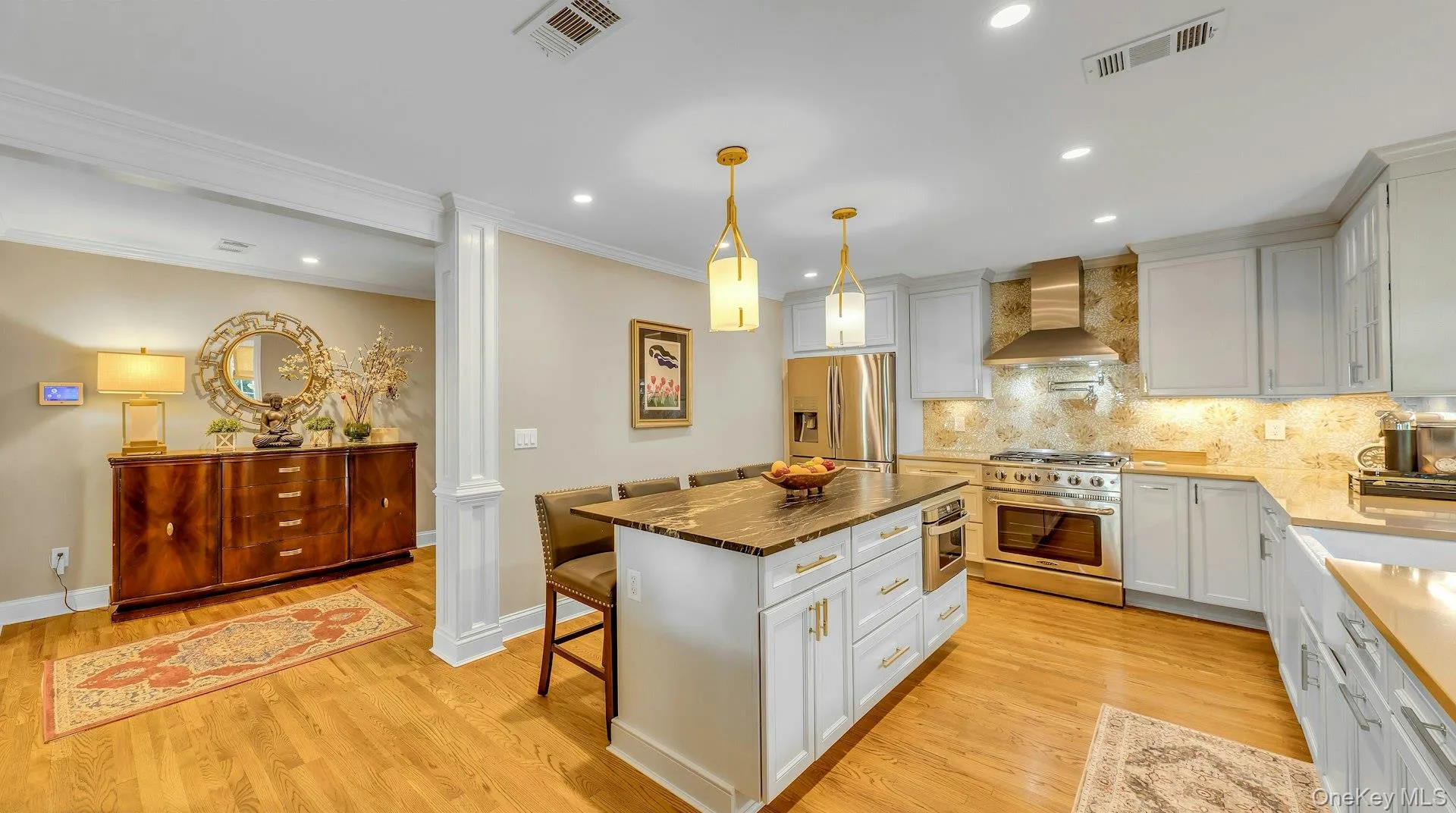 Hardwood flooring, white shaker cabinetry, stainless steel appliances, stone countertops, and recessed lighting Hardwood flooring, white shaker cabinetry, stainless steel appliances, stone countertops, and recessed lighting