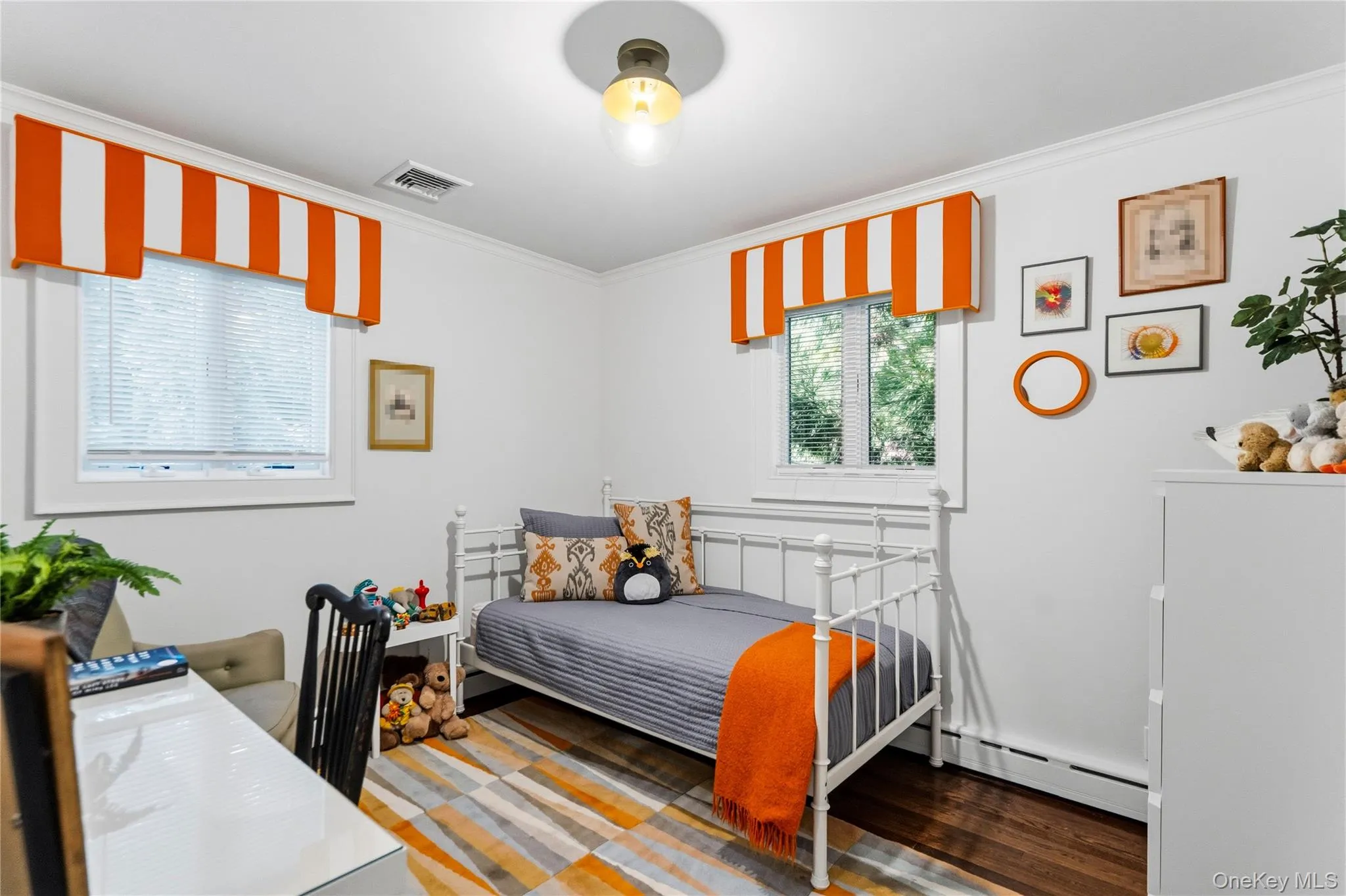 First Floor Bedroom featuring wood-finish flooring, two dual-pane windows with integrated blinds, and a central glass globe light fixture First Floor Bedroom featuring wood-finish flooring, two dual-pane windows with integrated blinds, and a central glass globe light fixture