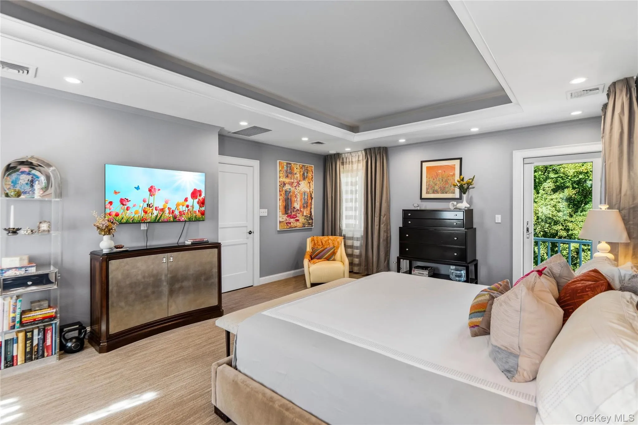 Tray ceiling with recessed lighting, neutral wall color, and glass door access to an exterior balcony Tray ceiling with recessed lighting, neutral wall color, and glass door access to an exterior balcony
