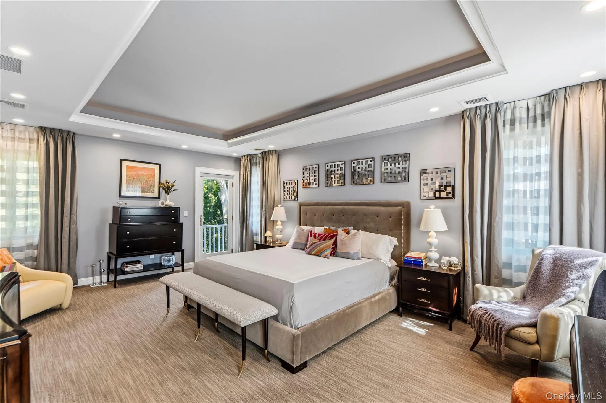 Tray ceiling with recessed lighting, integrated wall-to-wall carpeting, multiple windows with neutral drapery, and a glass-paneled exterior door Tray ceiling with recessed lighting, integrated wall-to-wall carpeting, multiple windows with neutral drapery, and a glass-paneled exterior door
