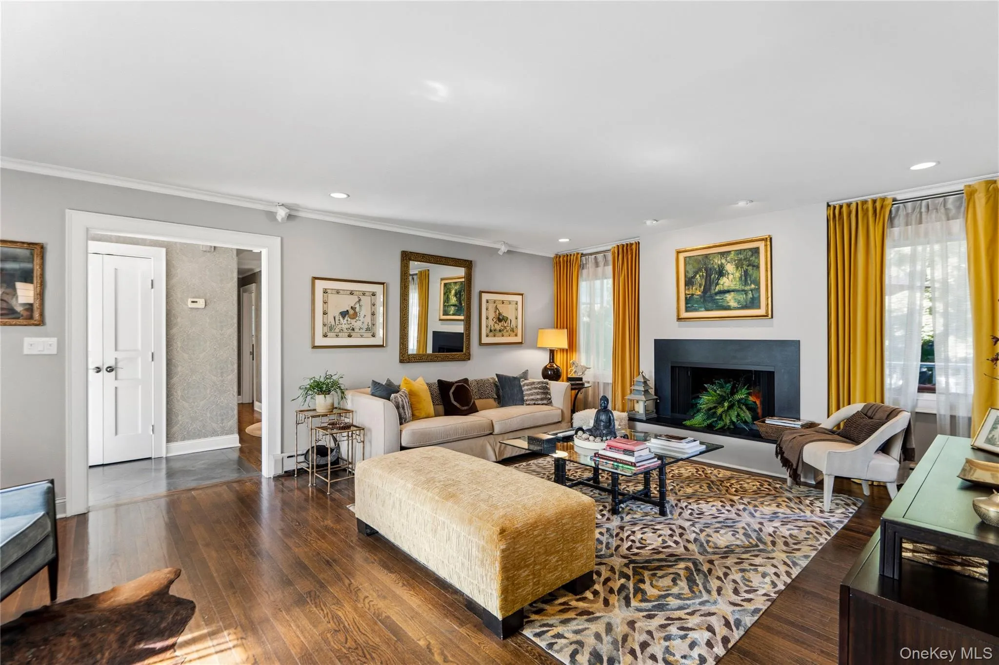Living space featuring wood-finish flooring, a granite fireplace surround, recessed lighting Living space featuring wood-finish flooring, a granite fireplace surround, recessed lighting