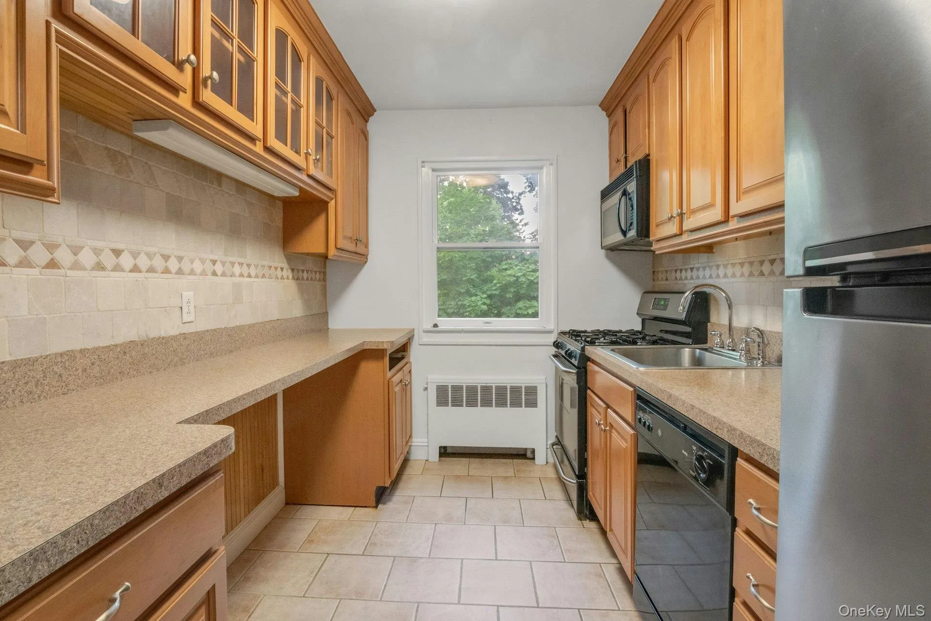 Updated Kitchen with Stainless Steel Appliances and Gas Range, Plenty of Cabinets and Counter Space Accommodating Stool Seating, Decorative Tile Backsplash and Tile Flooring. Updated Kitchen with Stainless Steel Appliances and Gas Range, Plenty of Cabinets and Counter Space Accommodating Stool Seating, Decorative Tile Backsplash and Tile Flooring.