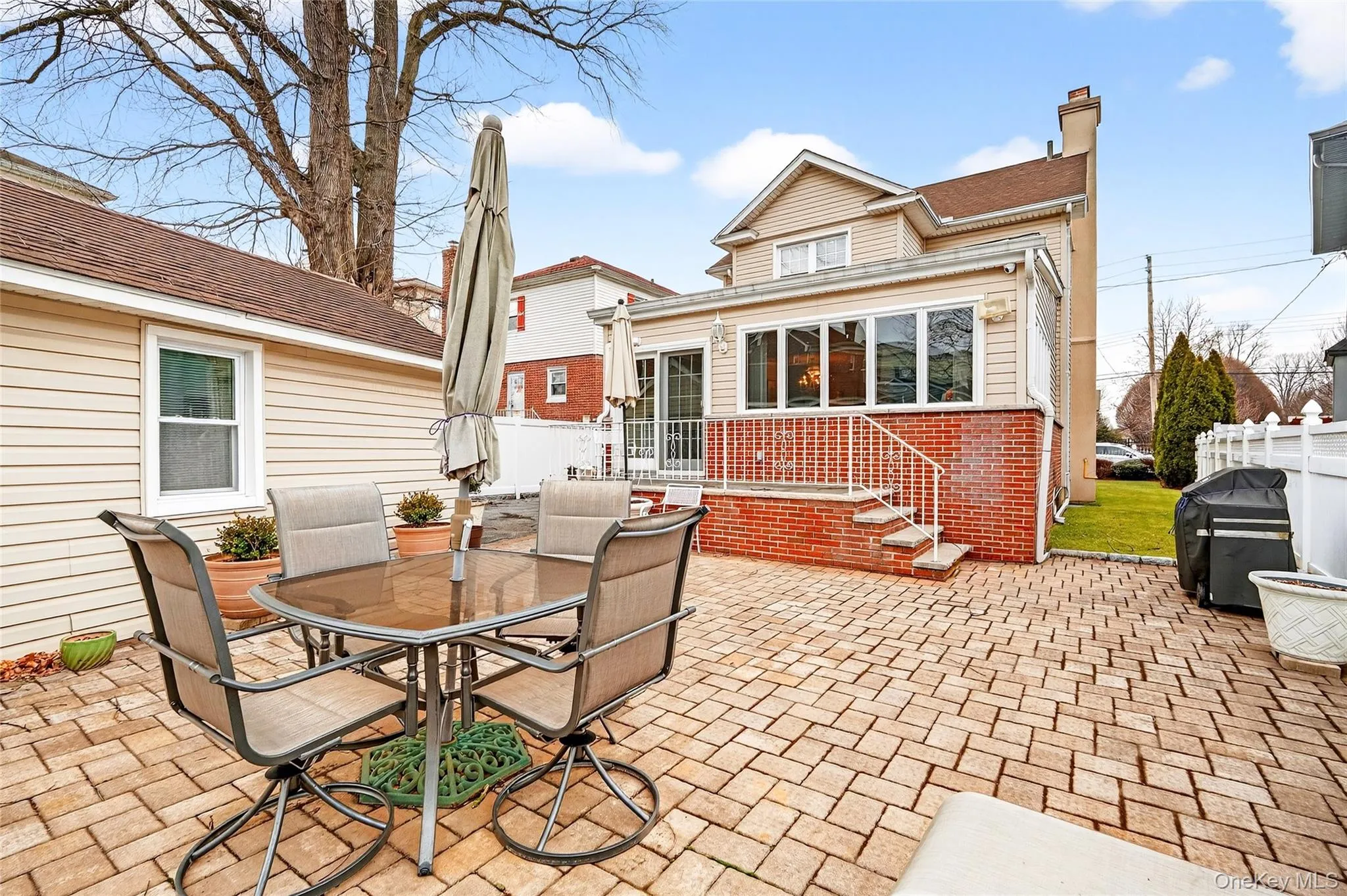 Back of property featuring outdoor dining space, a patio, a chimney, brick siding, and roof with shingles Back of property featuring outdoor dining space, a patio, a chimney, brick siding, and roof with shingles