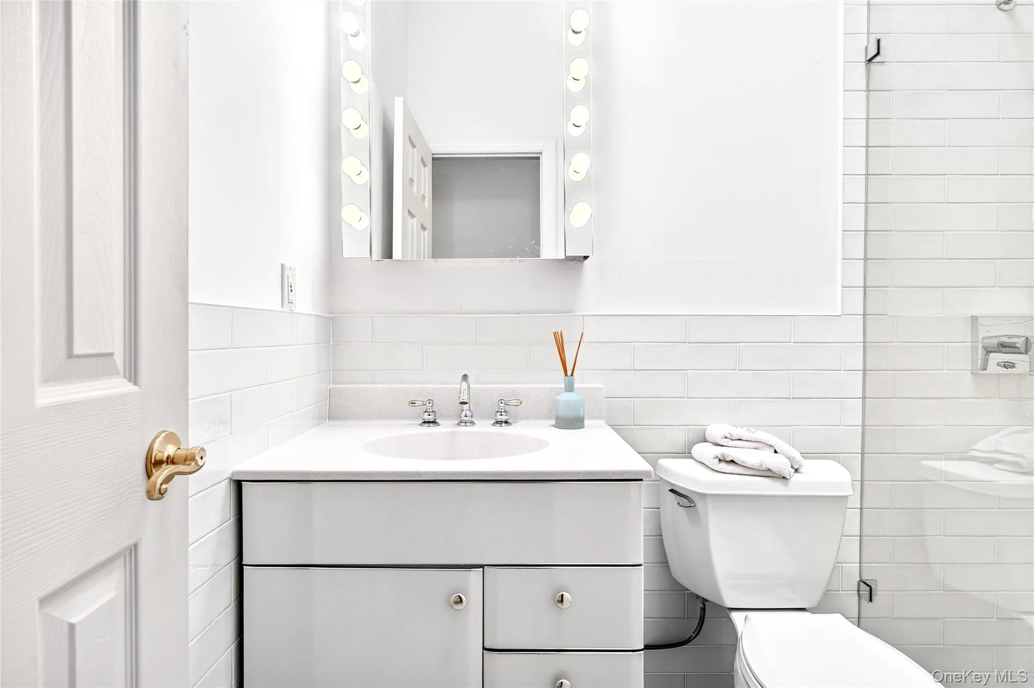 Full bath featuring vanity, tile walls, a tile shower, and decorative backsplash Full bath featuring vanity, tile walls, a tile shower, and decorative backsplash