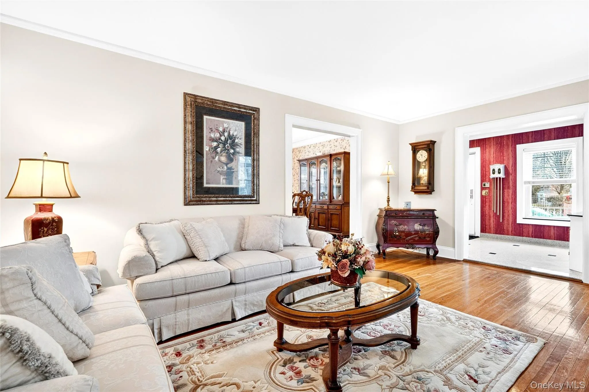 Living room featuring hardwood / wood-style floors, plenty of natural light, and ornamental molding Living room featuring hardwood / wood-style floors, plenty of natural light, and ornamental molding