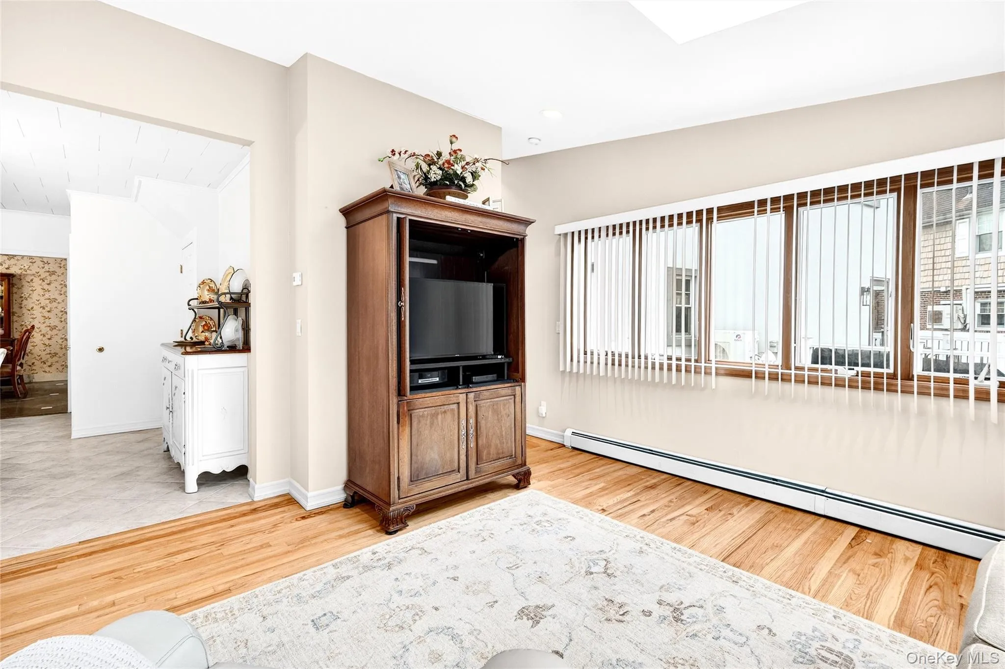 Living area with baseboard heating, healthy amount of natural light, and light wood-type flooring Living area with baseboard heating, healthy amount of natural light, and light wood-type flooring
