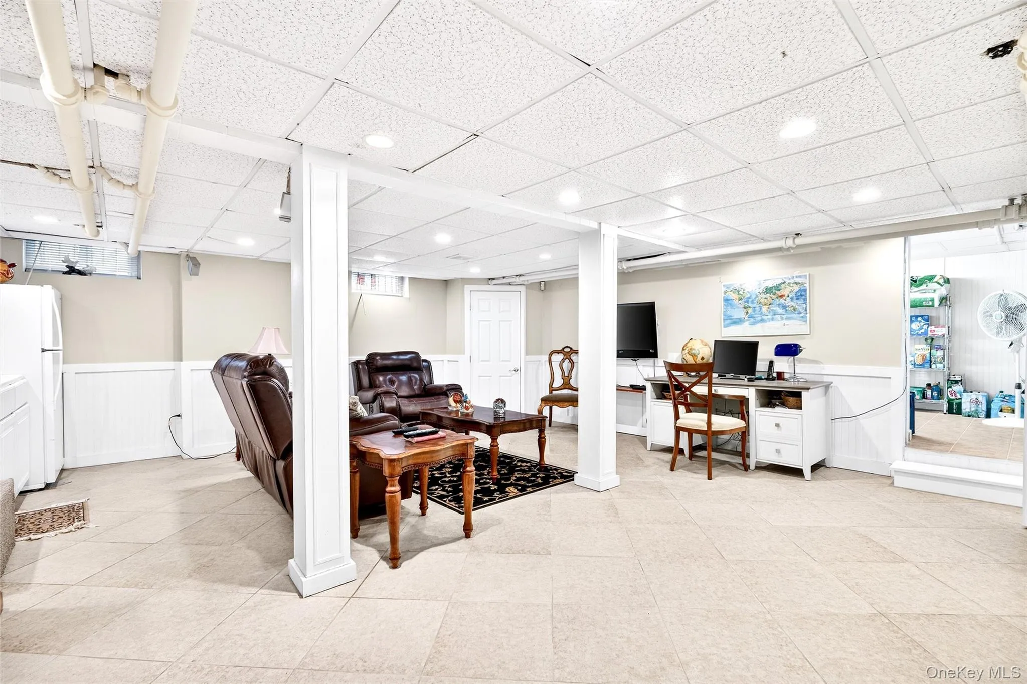 Office area featuring a wainscoted wall, a paneled ceiling, and light tile patterned floors Office area featuring a wainscoted wall, a paneled ceiling, and light tile patterned floors