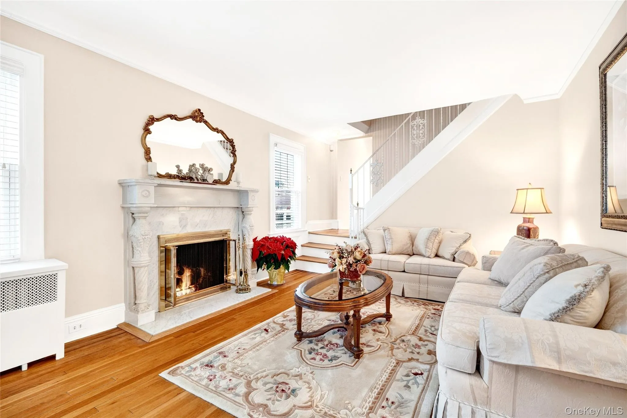 Living room featuring a fireplace, wood finished floors, and radiator heating unit Living room featuring a fireplace, wood finished floors, and radiator heating unit