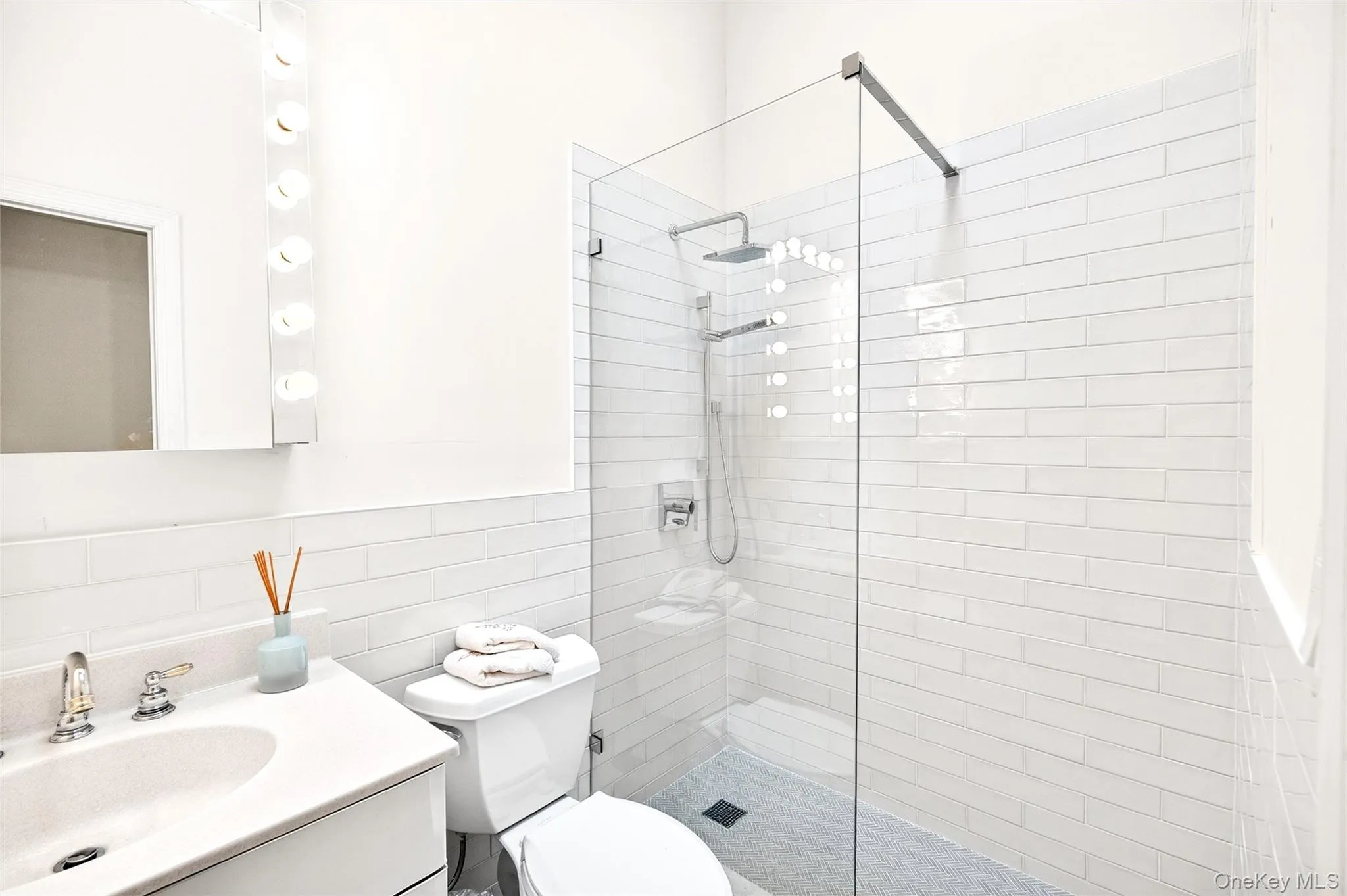 Bathroom with walk in shower, vanity, decorative backsplash, and tile walls Bathroom with walk in shower, vanity, decorative backsplash, and tile walls