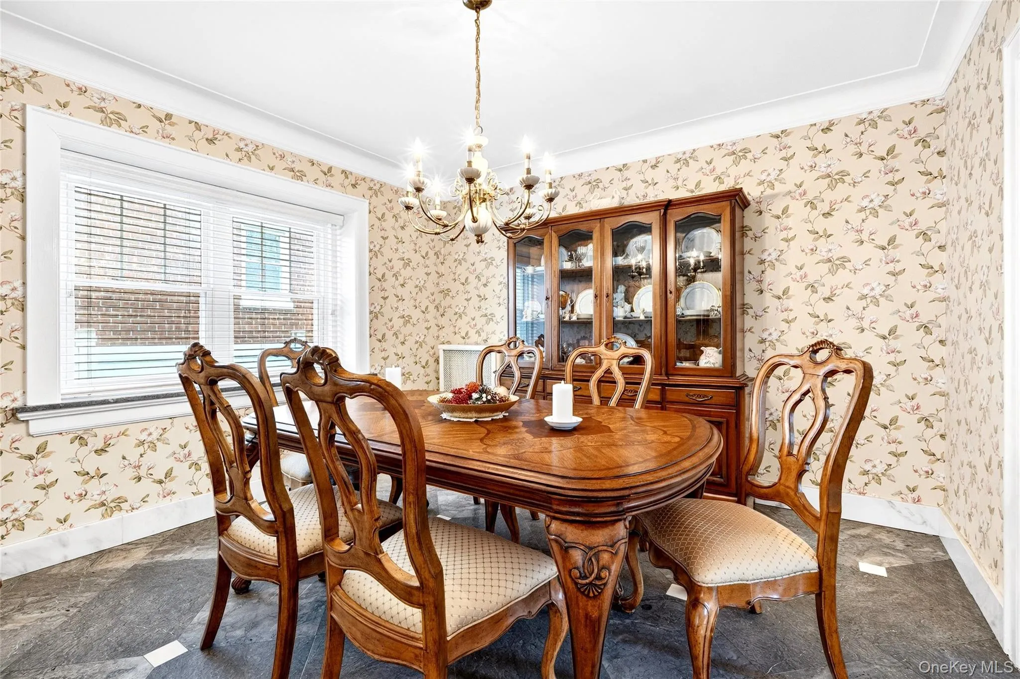 Dining space featuring wallpapered walls, a chandelier, and crown molding Dining space featuring wallpapered walls, a chandelier, and crown molding