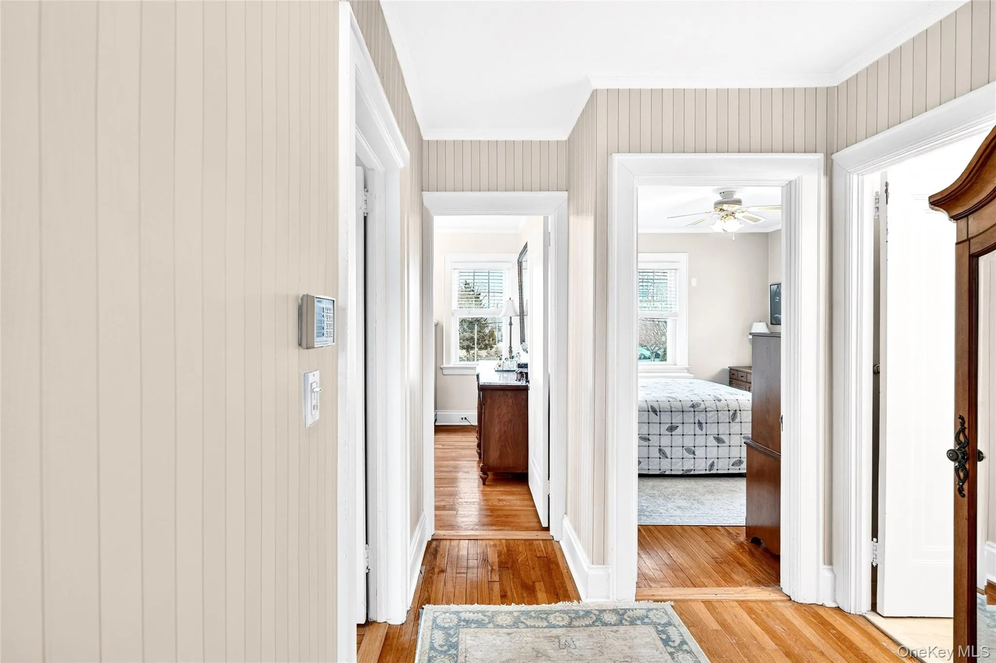 Hallway with light wood-type flooring and ornamental molding Hallway with light wood-type flooring and ornamental molding