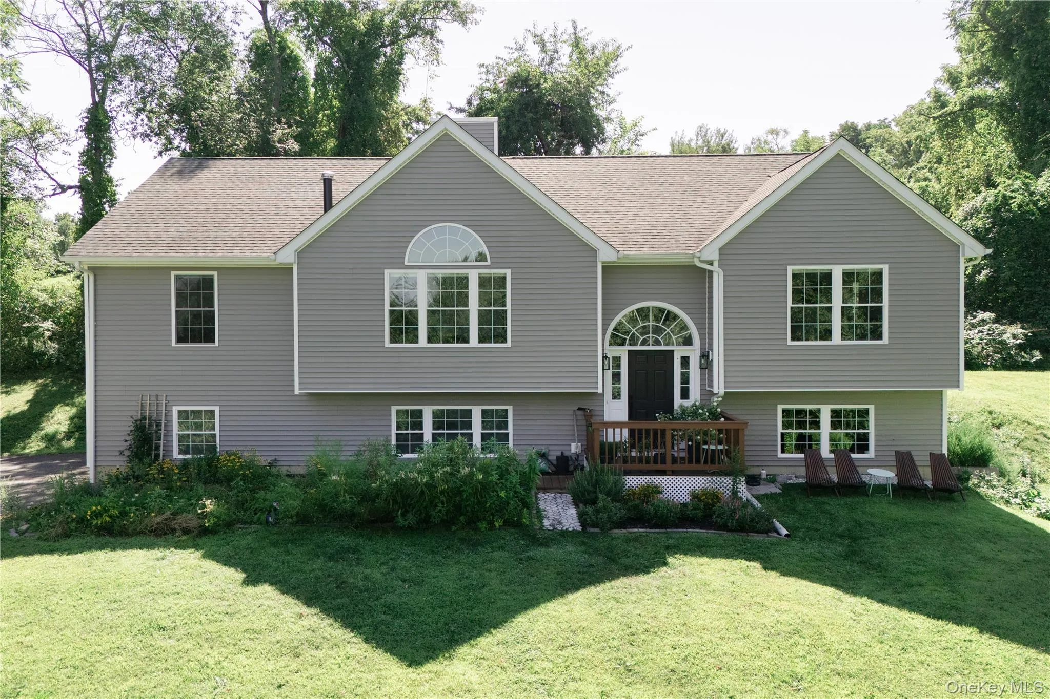 Two-story residence featuring gray siding and a brown shingle roof Two-story residence featuring gray siding and a brown shingle roof