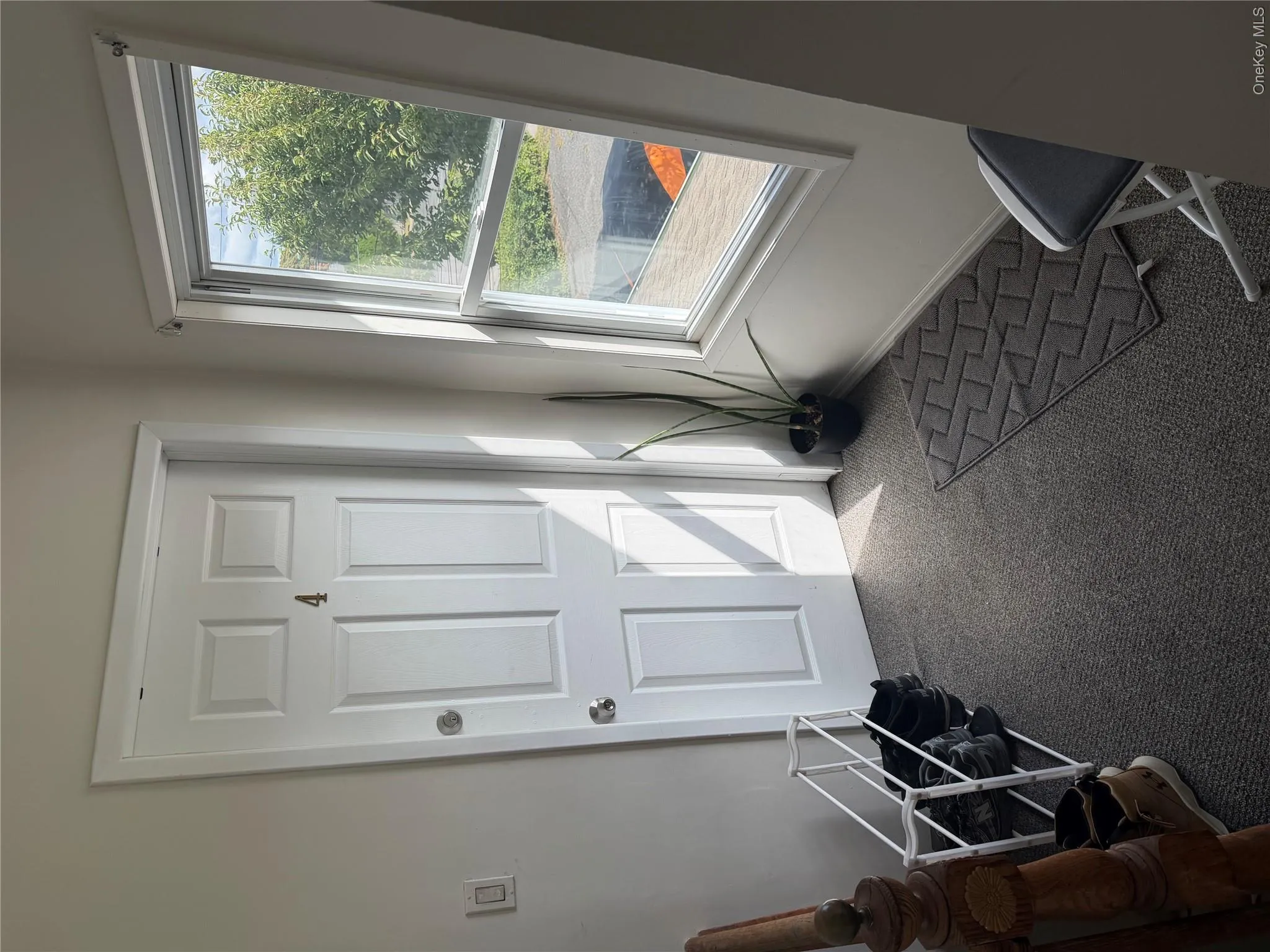 Panel door with numerical designation, single-pane window with white trim, and gray carpet Panel door with numerical designation, single-pane window with white trim, and gray carpet