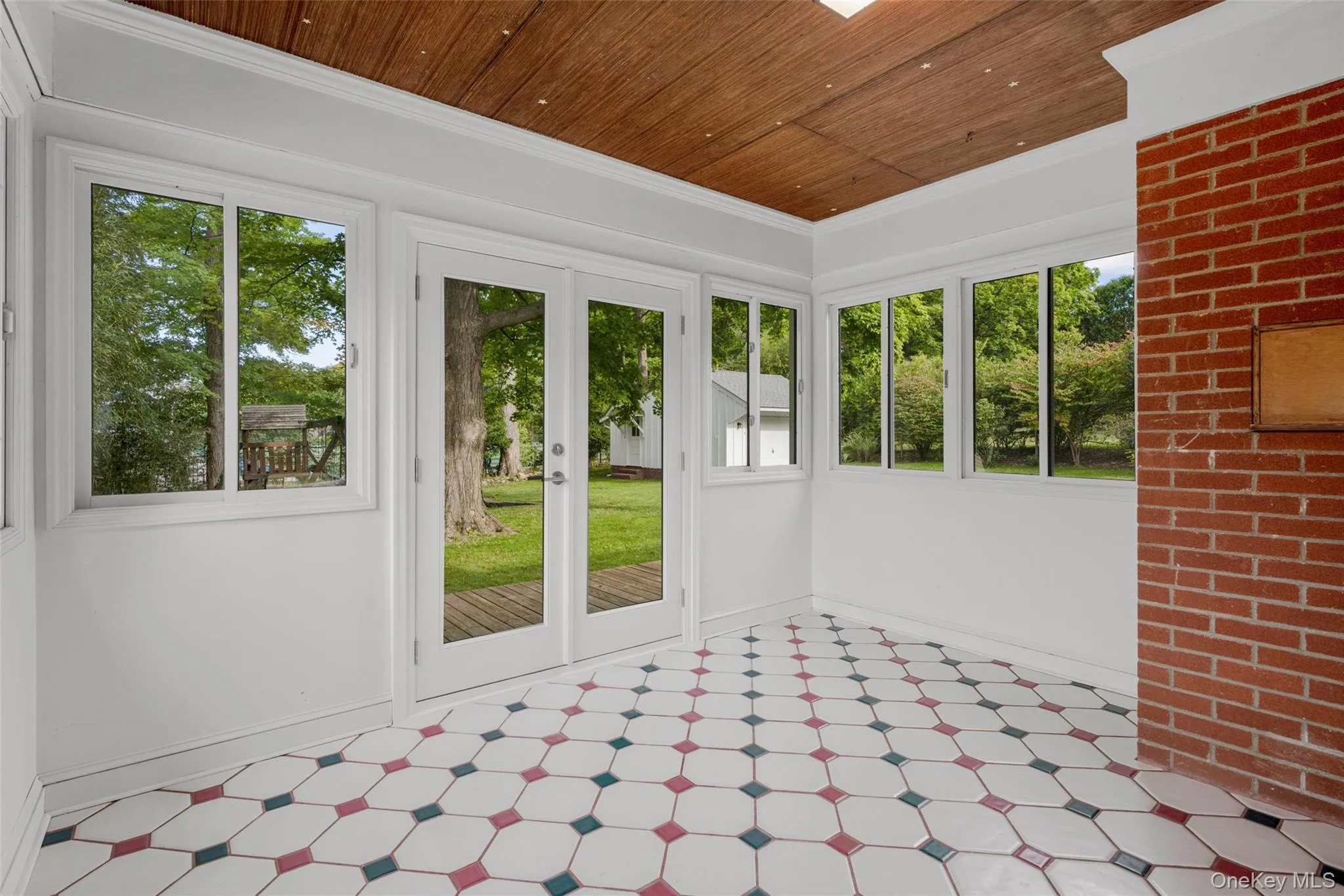 Tiled sunroom with new french doors to the deck and back yard Tiled sunroom with new french doors to the deck and back yard