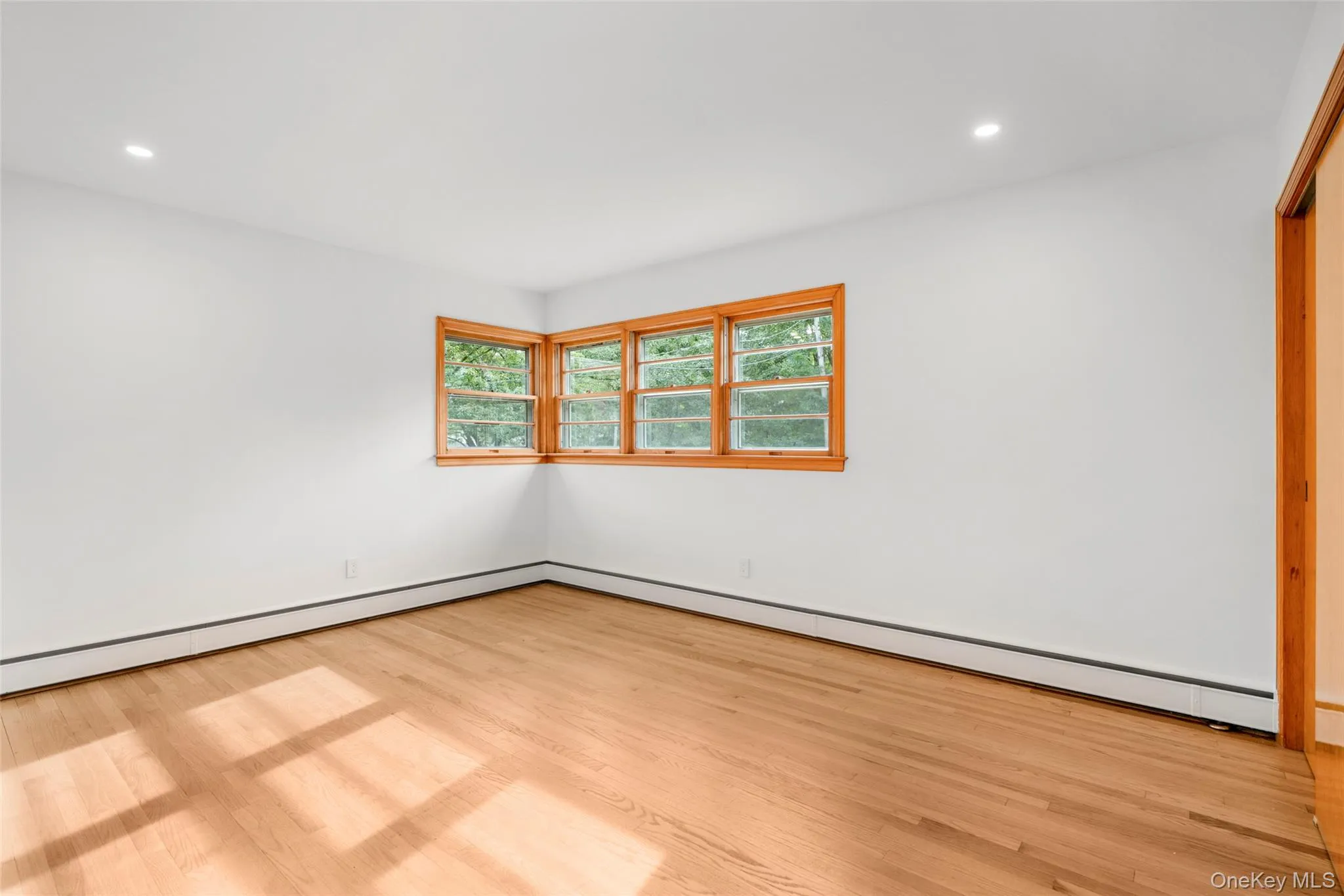 Mid-century corner window and pristine oak floors in primary bedroom Mid-century corner window and pristine oak floors in primary bedroom
