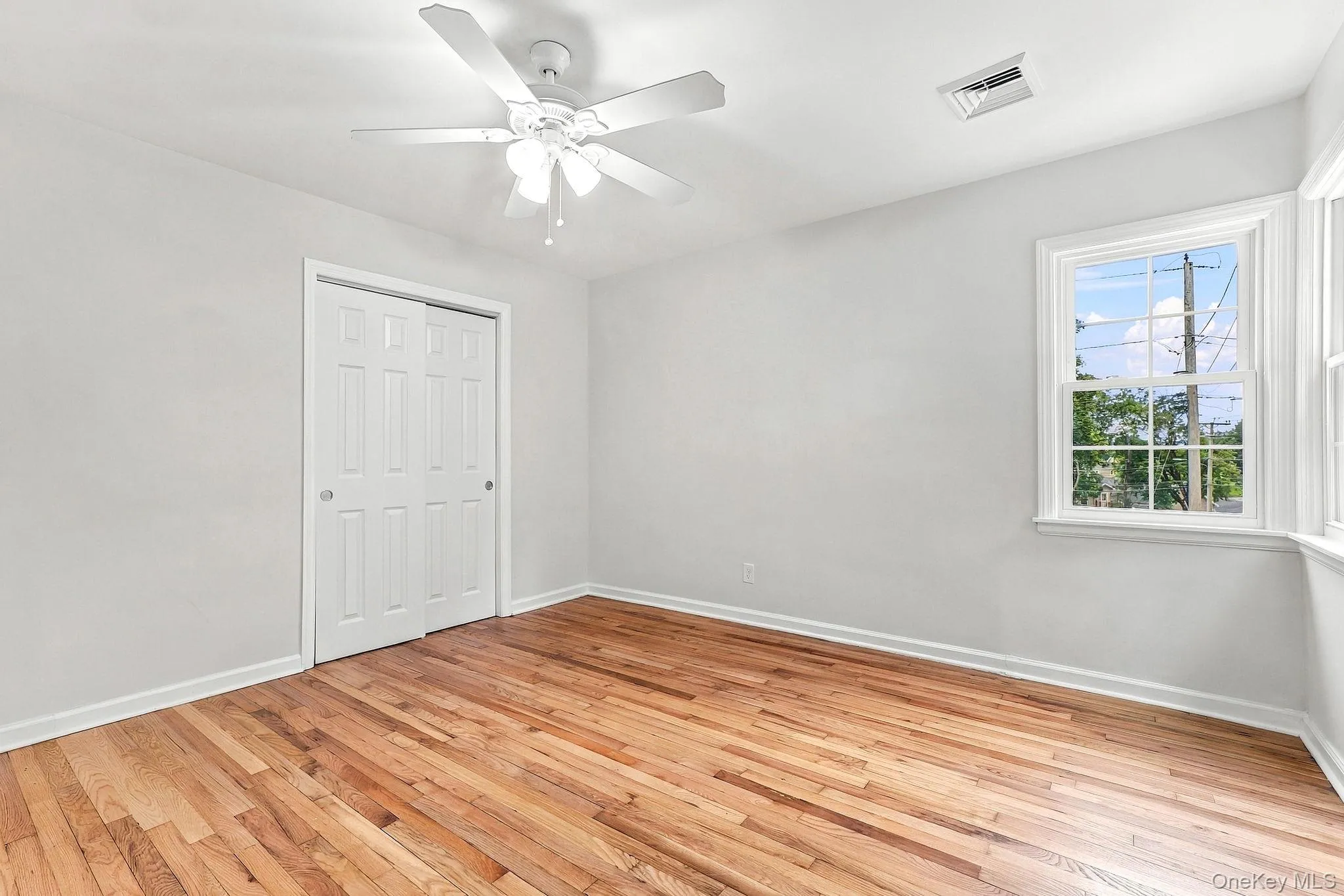 Wood-finish flooring, white walls, and a ceiling fan with integrated lighting Wood-finish flooring, white walls, and a ceiling fan with integrated lighting