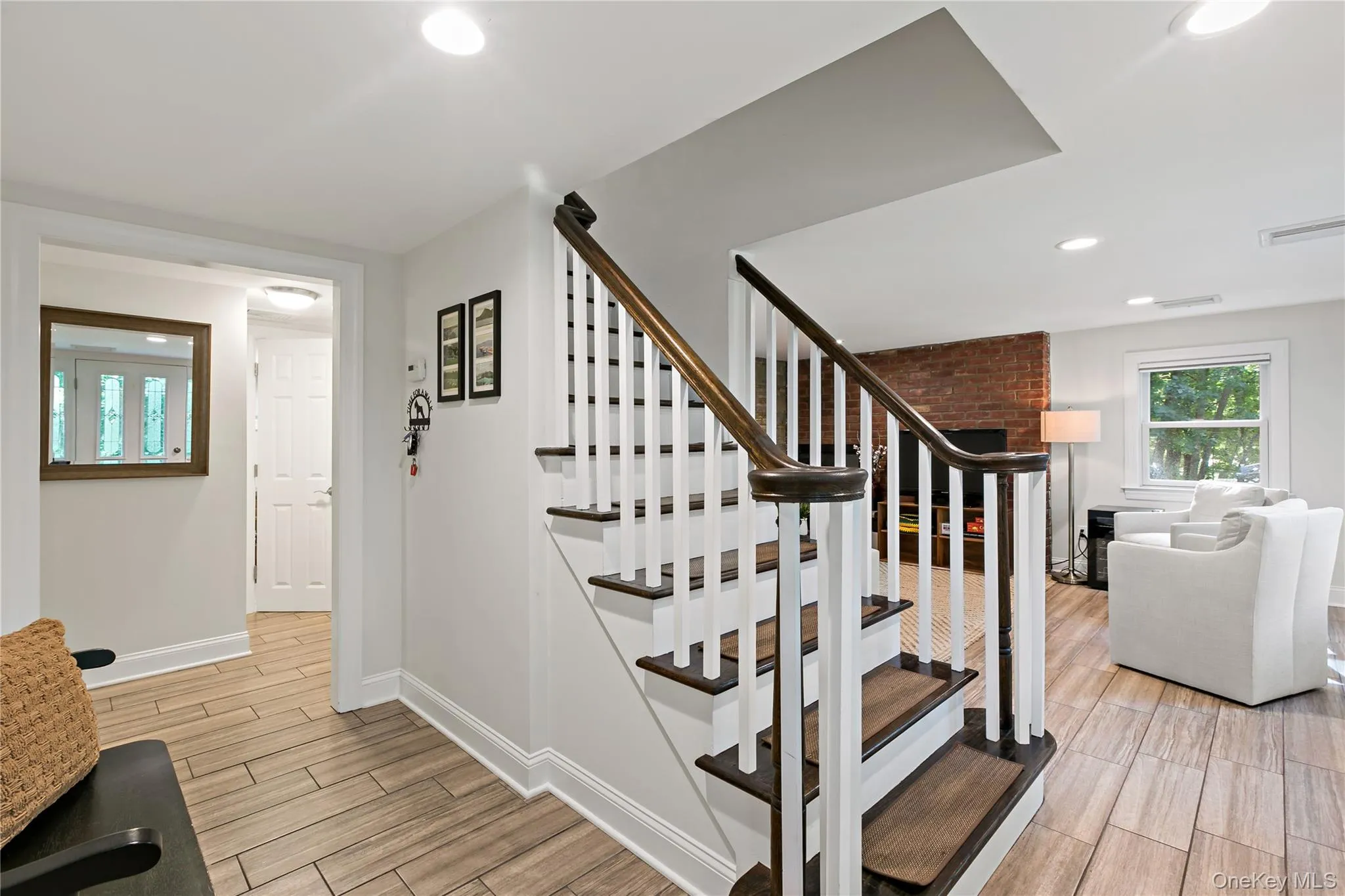 View of stairs to upper living level and Family Room in background View of stairs to upper living level and Family Room in background