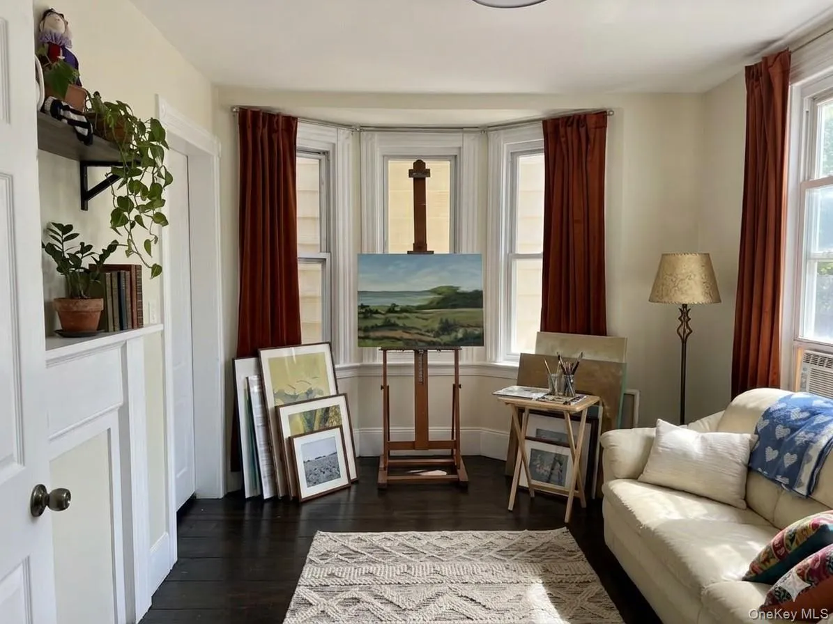 Virtually Staged. Sunny, comfortable living room with decorative fireplace and window facing Beekman Avenue. Virtually Staged. Sunny, comfortable living room with decorative fireplace and window facing Beekman Avenue.