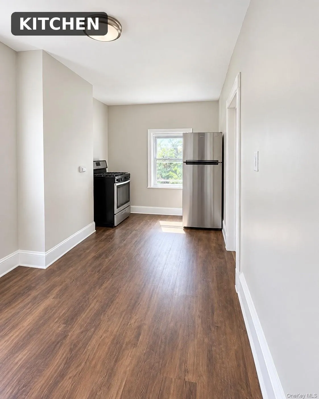 Wood-finish flooring with a stainless steel refrigerator and black range Wood-finish flooring with a stainless steel refrigerator and black range