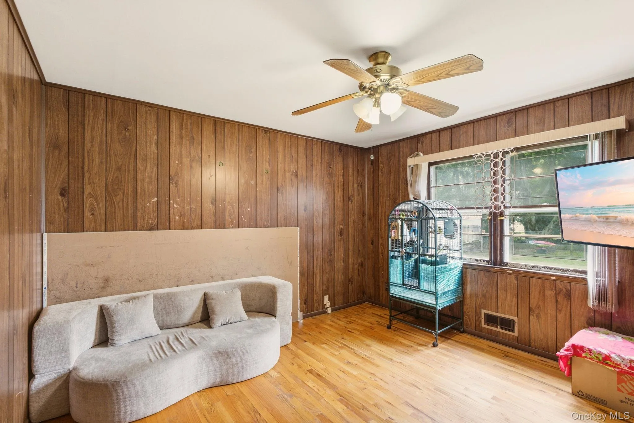 Wood-paneled walls and a ceiling fan with integrated lighting Wood-paneled walls and a ceiling fan with integrated lighting