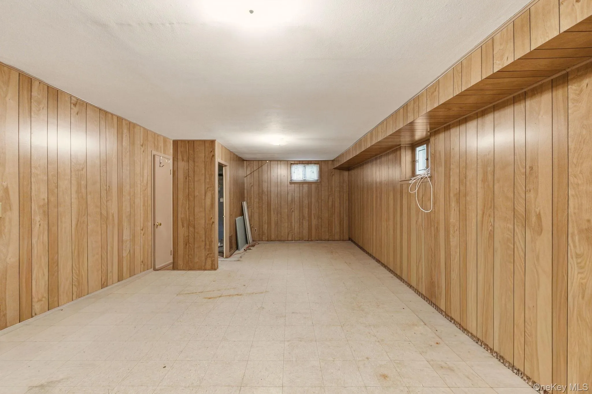 Wood-finish wall paneling, recessed lighting, and vinyl flooring Wood-finish wall paneling, recessed lighting, and vinyl flooring