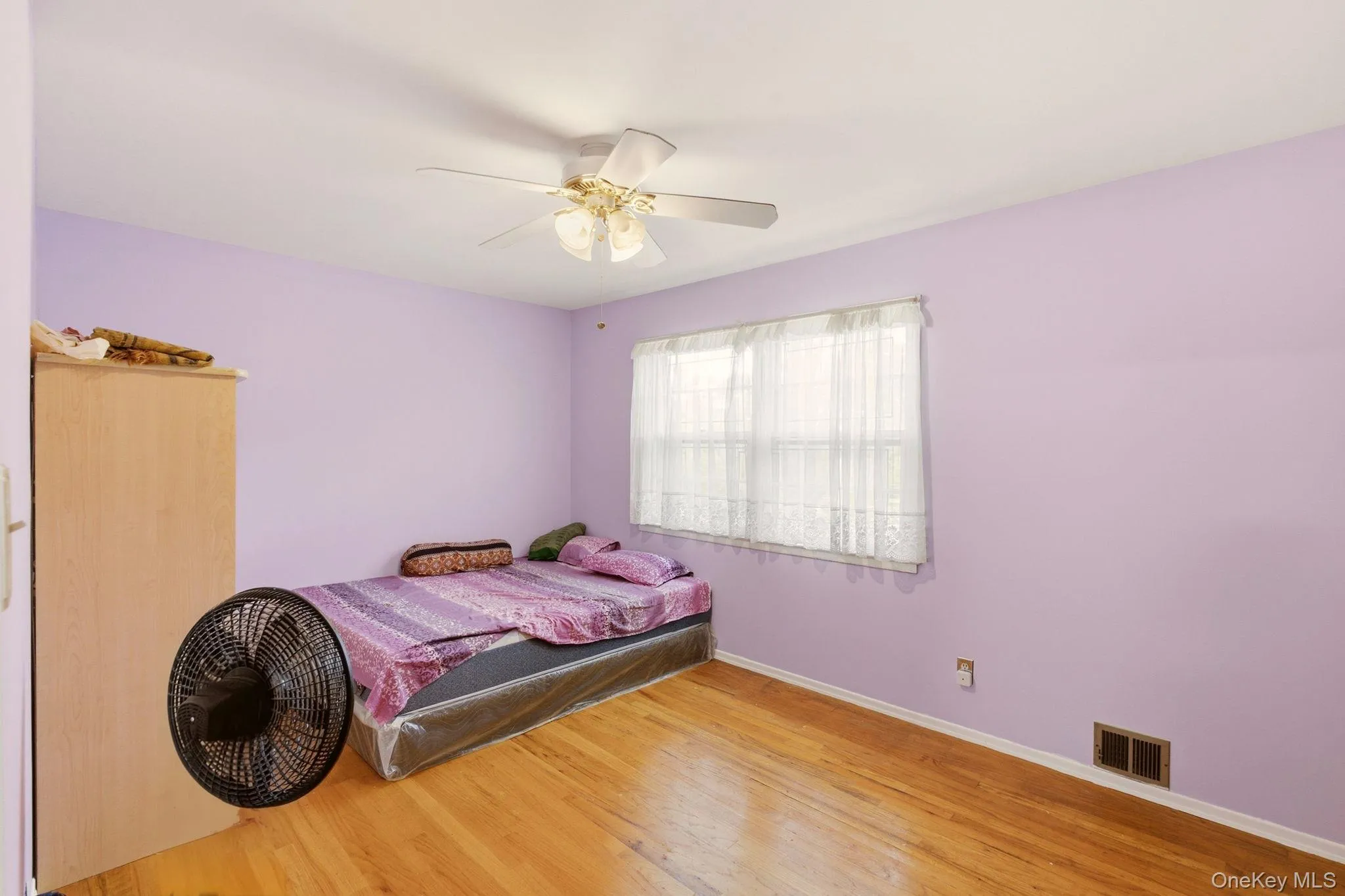 Wood-finish flooring, ceiling fan, and window with blinds Wood-finish flooring, ceiling fan, and window with blinds