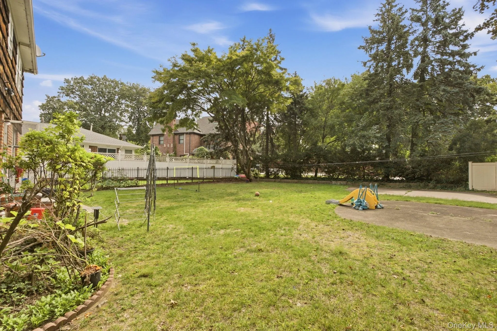Expansive lawn area, mature trees, white picket fencing, and paved surface Expansive lawn area, mature trees, white picket fencing, and paved surface