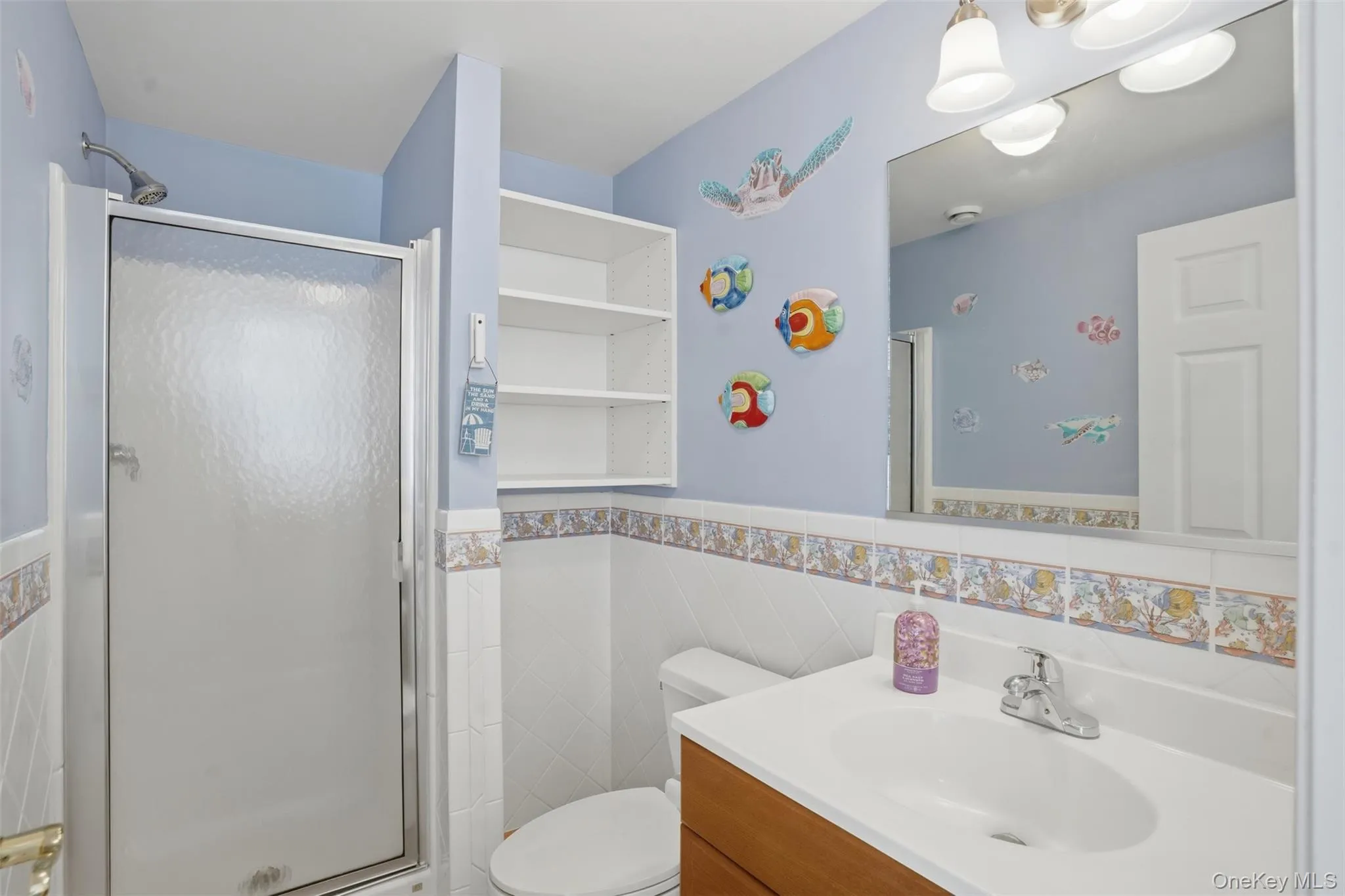 The bathroom features a vanity with a white sink and a mirror above The bathroom features a vanity with a white sink and a mirror above