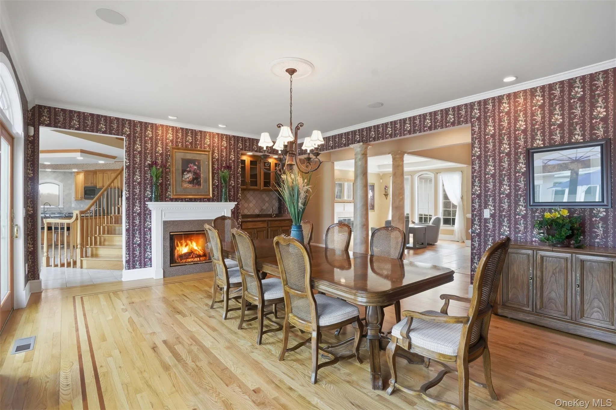 Dining area featuring hardwood floors, a fireplace, and decorative wall coverings Dining area featuring hardwood floors, a fireplace, and decorative wall coverings