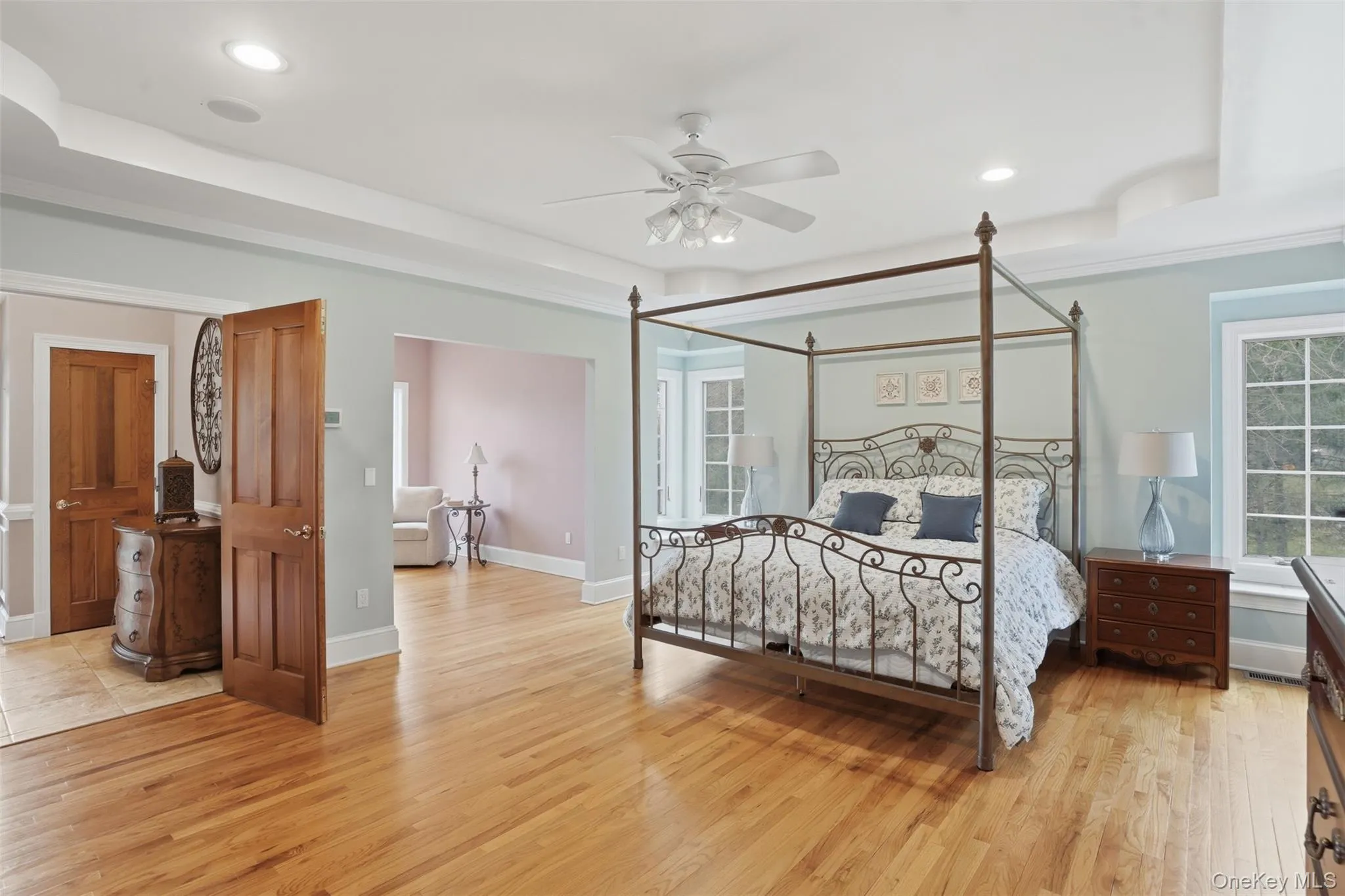 This spacious room features hardwood floors, a ceiling fan, recessed lighting, and windows providing natural light This spacious room features hardwood floors, a ceiling fan, recessed lighting, and windows providing natural light