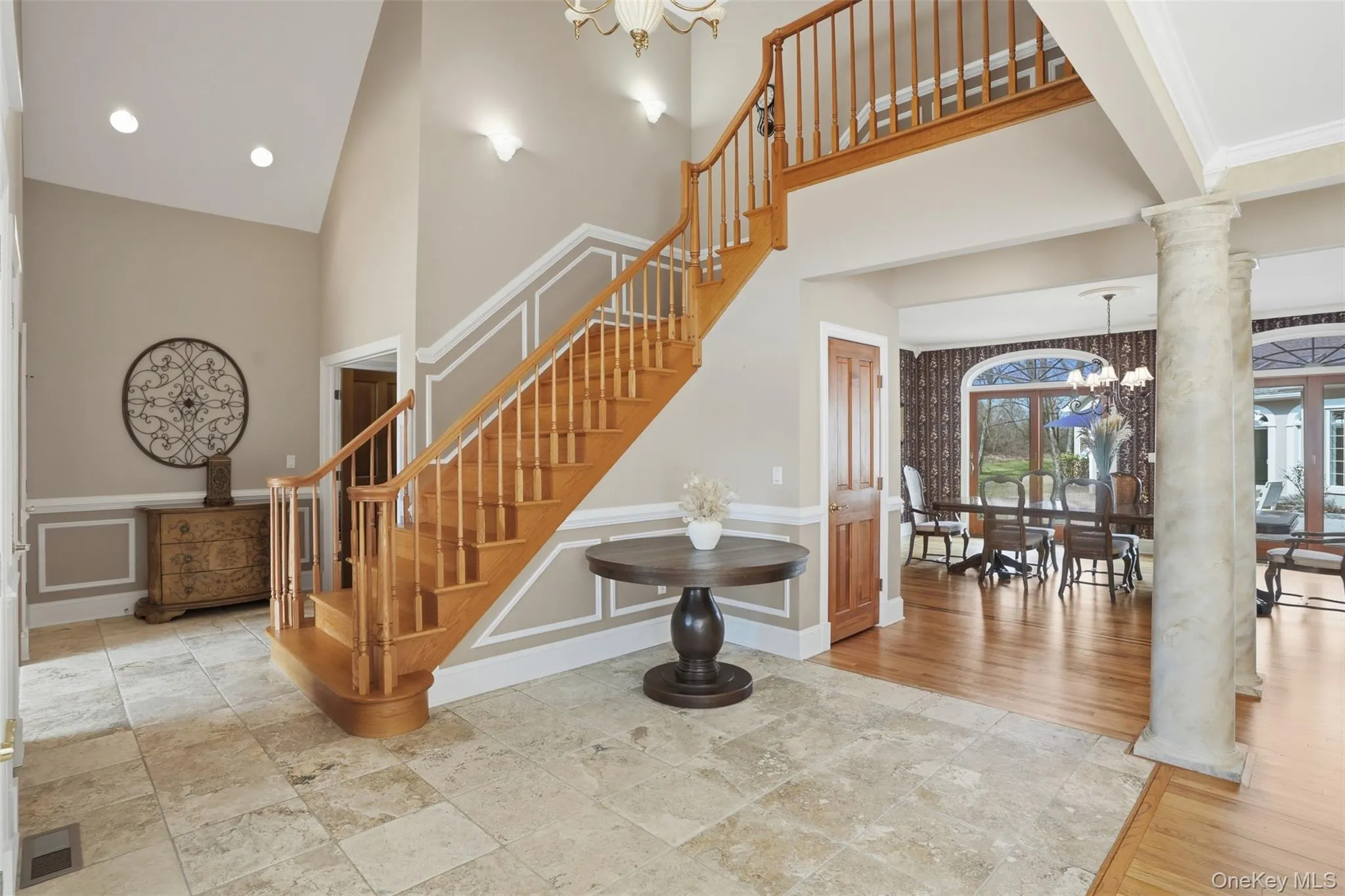 Grand foyer featuring a natural wood staircase with white risers, a vaulted ceiling, and recessed lighting Grand foyer featuring a natural wood staircase with white risers, a vaulted ceiling, and recessed lighting
