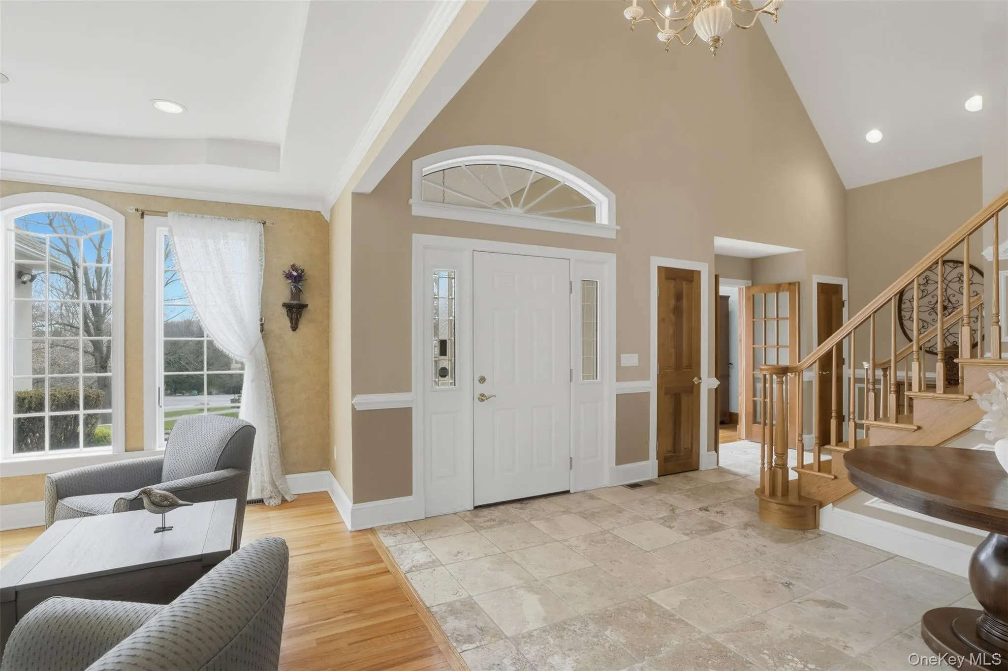 The property features a grand entryway with high ceilings, an elegant staircase with wood banisters, and arched windows The property features a grand entryway with high ceilings, an elegant staircase with wood banisters, and arched windows