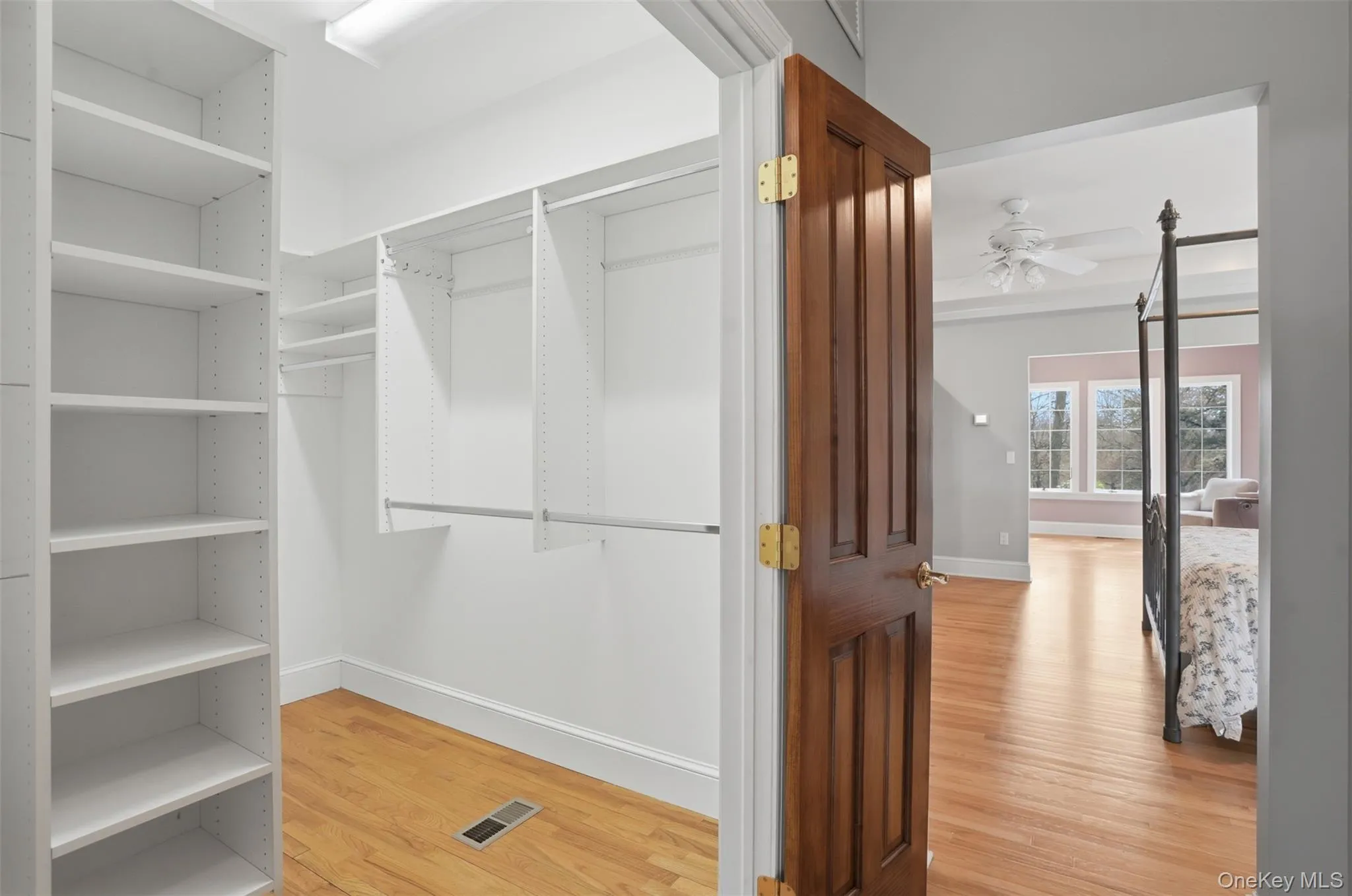 Walk-in closet featuring extensive built-in shelving and hanging rods Walk-in closet featuring extensive built-in shelving and hanging rods