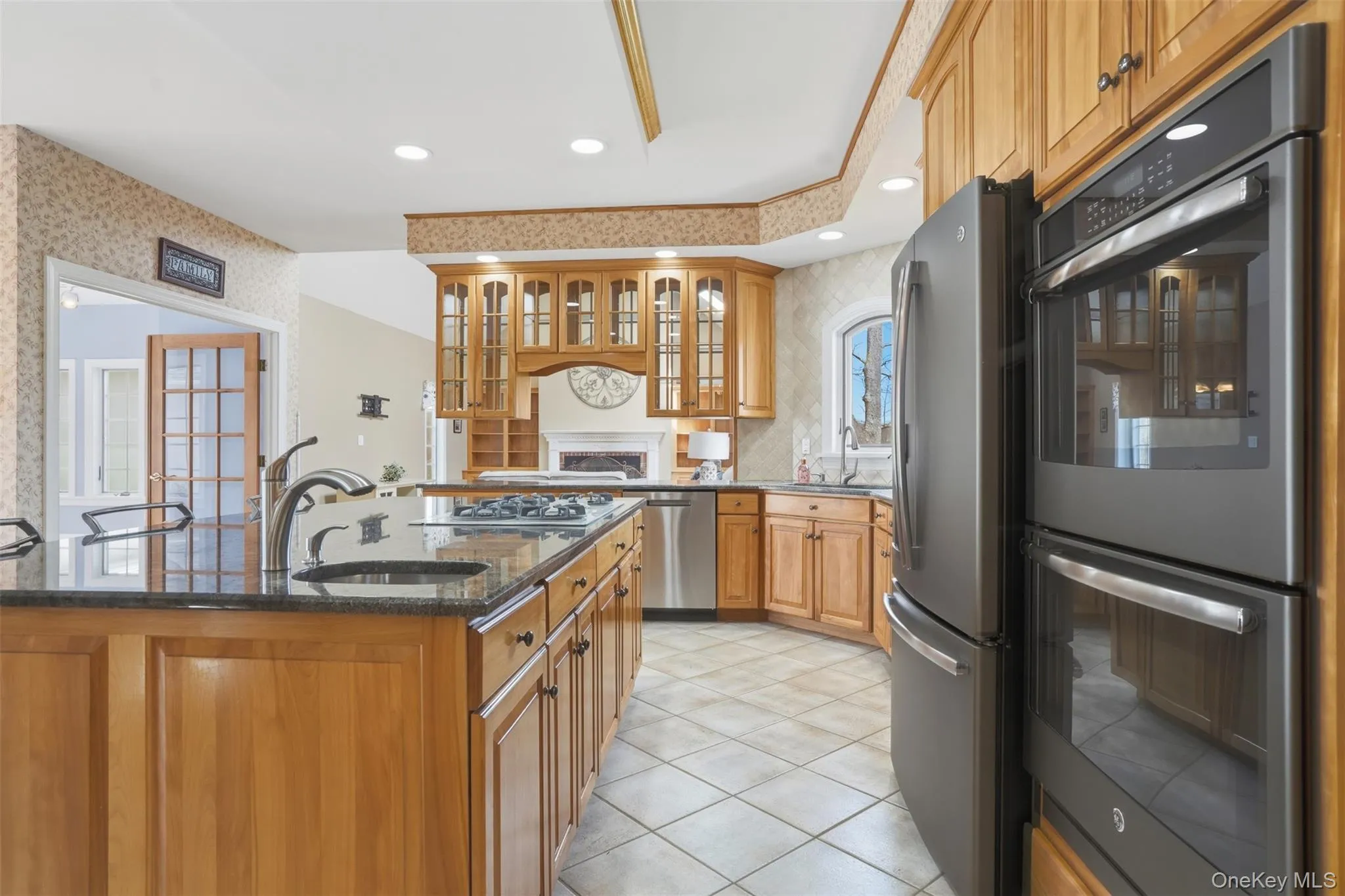 The kitchen features solid wood cabinetry, a large kitchen island with a sink, a gas stovetop, and stainless steel appliances The kitchen features solid wood cabinetry, a large kitchen island with a sink, a gas stovetop, and stainless steel appliances