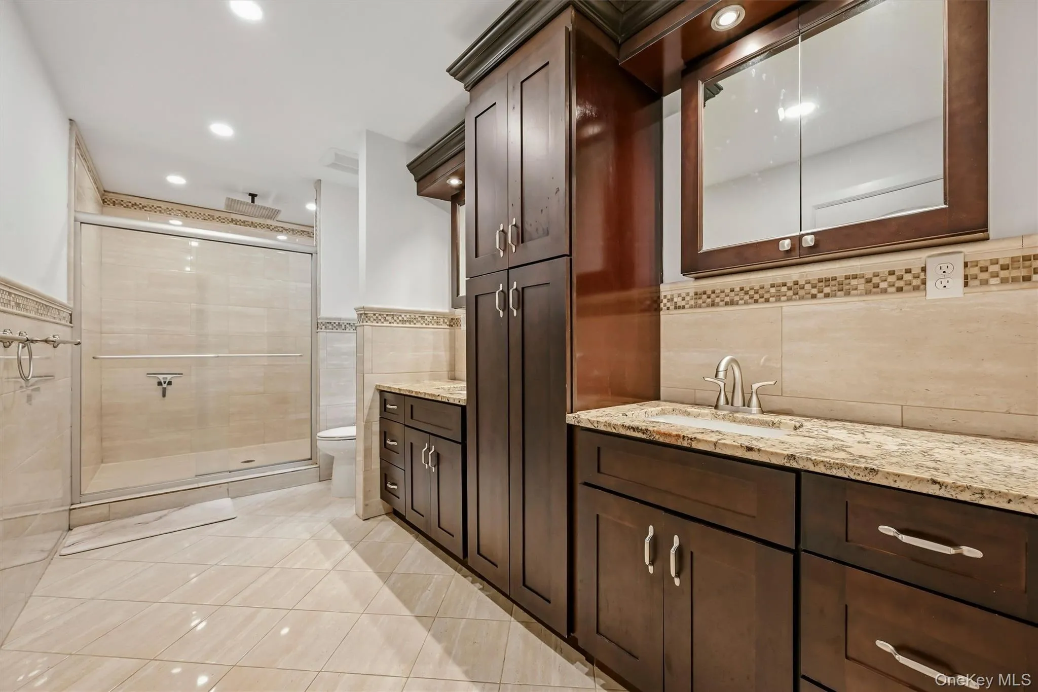 Primary bathroom with granite vanities, marble tile oversized shower with rainfall shower head. WIC access in primary bath. Primary bathroom with granite vanities, marble tile oversized shower with rainfall shower head. WIC access in primary bath.