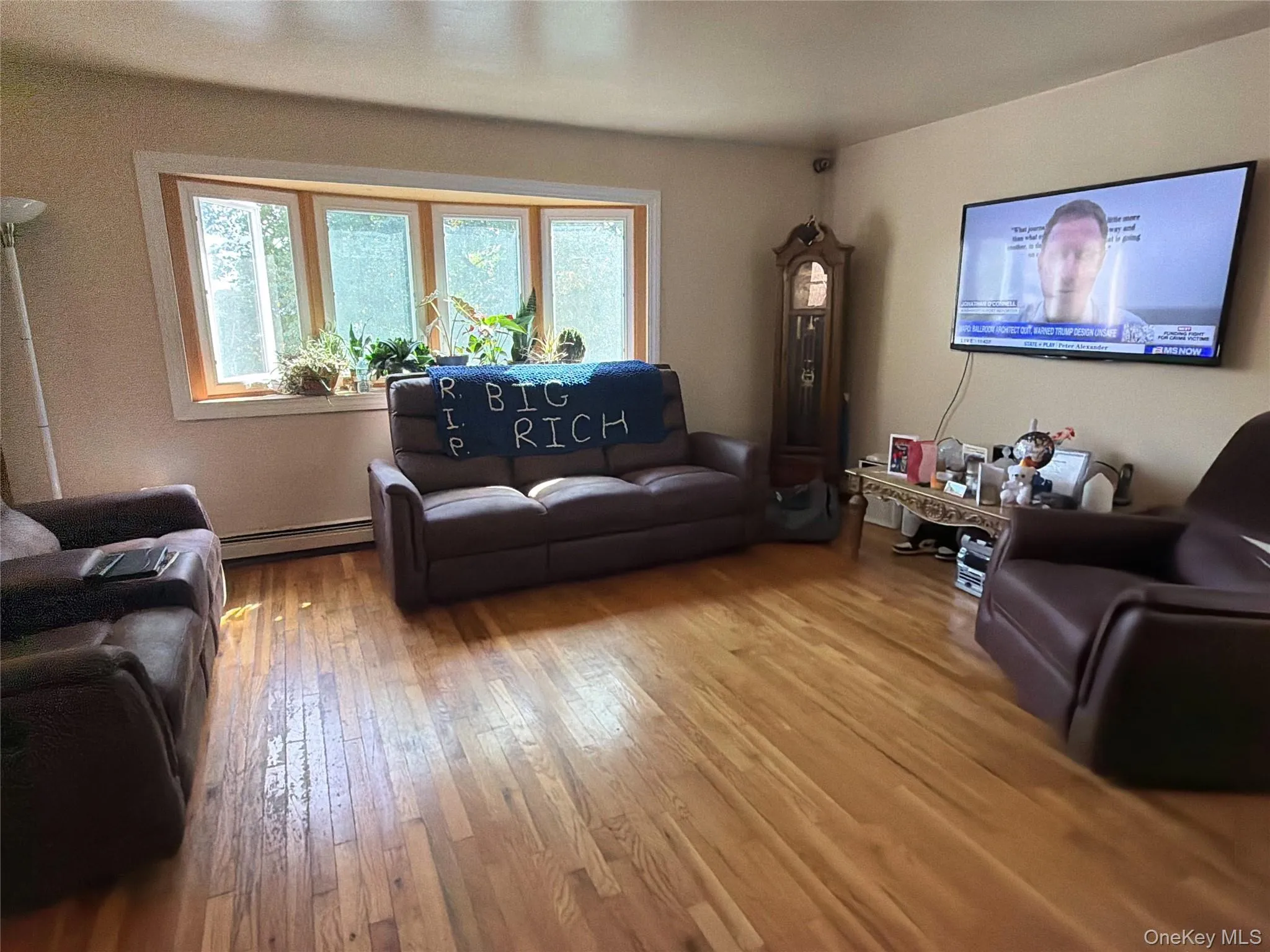 Hardwood flooring throughout, bay window with wood trim, and wall-mounted television Hardwood flooring throughout, bay window with wood trim, and wall-mounted television