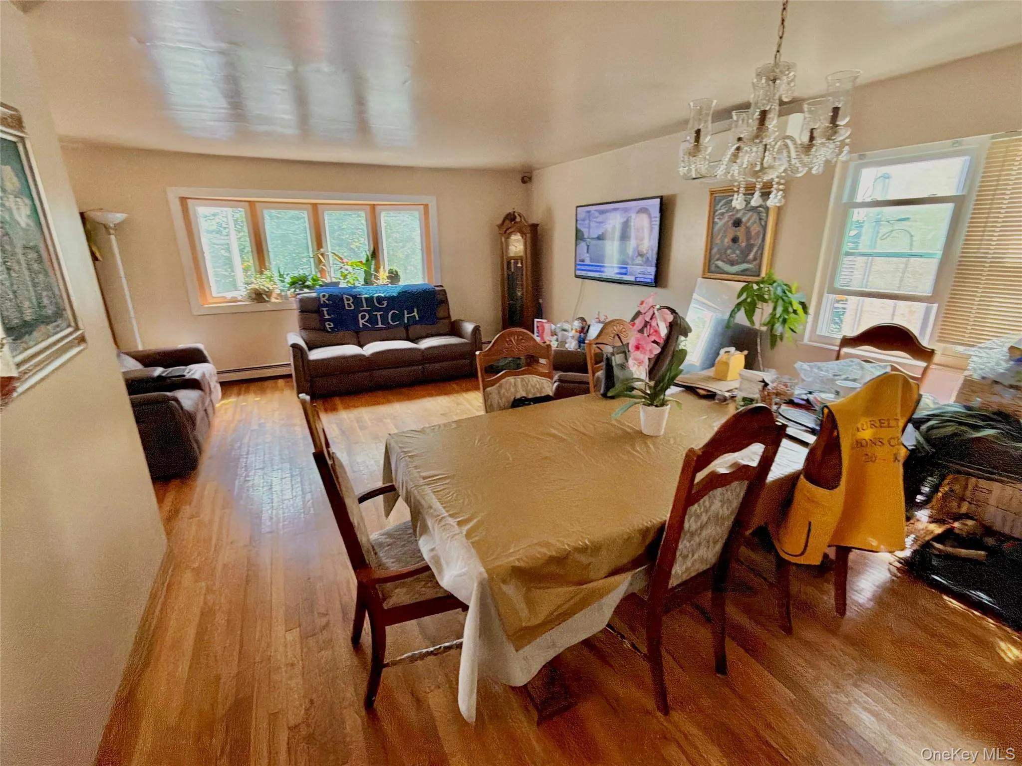 Hardwood flooring throughout, multiple windows, and a clear glass chandelier Hardwood flooring throughout, multiple windows, and a clear glass chandelier
